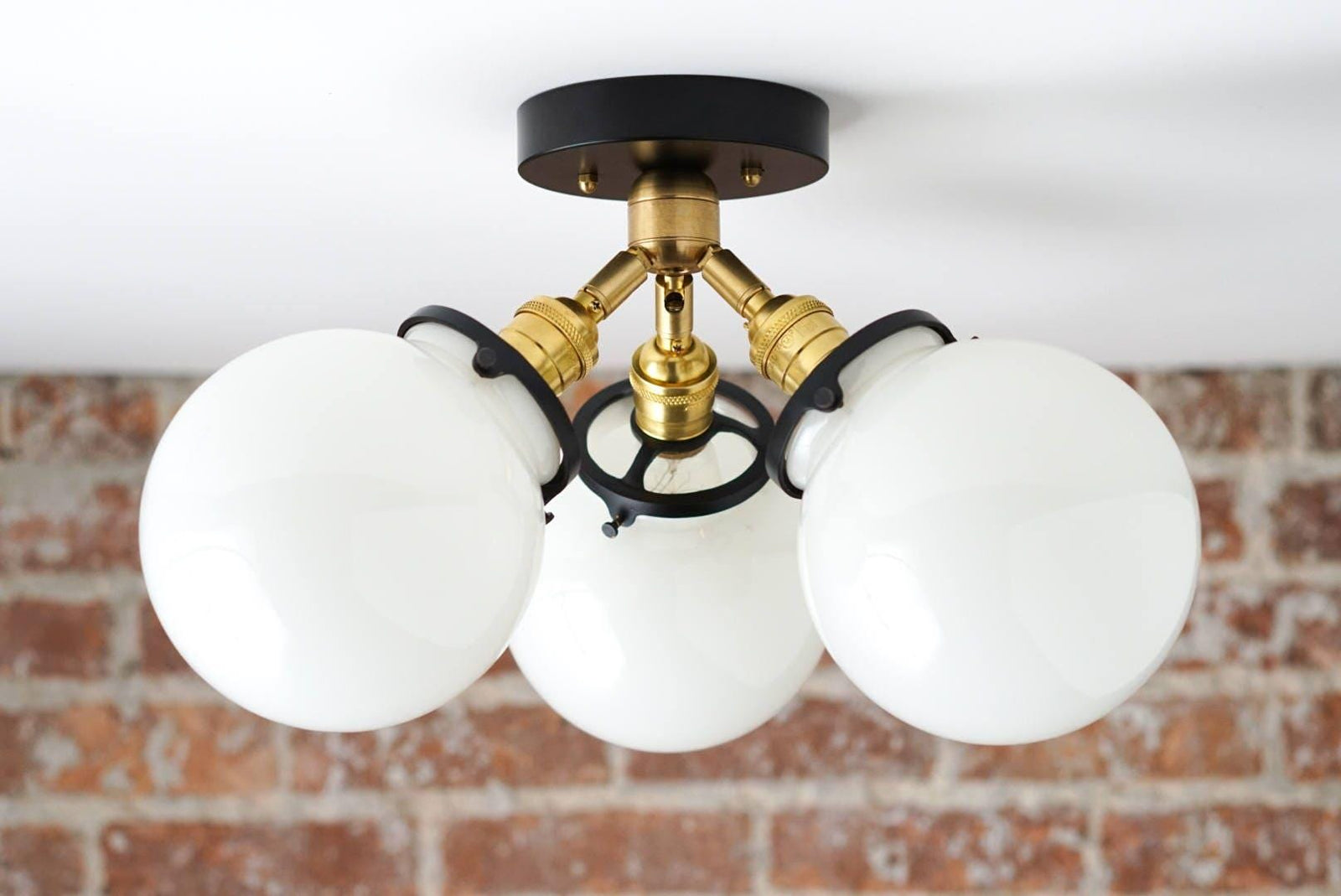 Mid-century modern flush mount ceiling light with three white glass globes and black and brass metal accents. - CEILING LIGHT MODEL NO. 0210