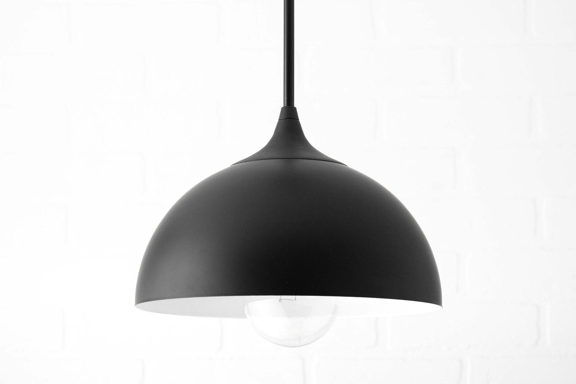 Black dome-shaped pendant light with white interior and exposed bulb hanging from black cord. - PENDANT MODEL NO. 9263