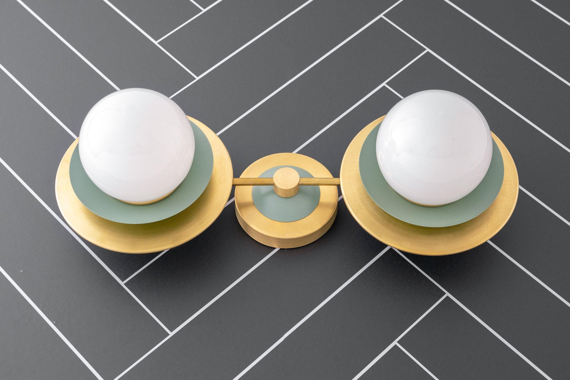 Mid-century modern vanity light with raw brass fixture and green round backplates, two white globe bulbs. - VANITY LIGHT MODEL NO. 9361