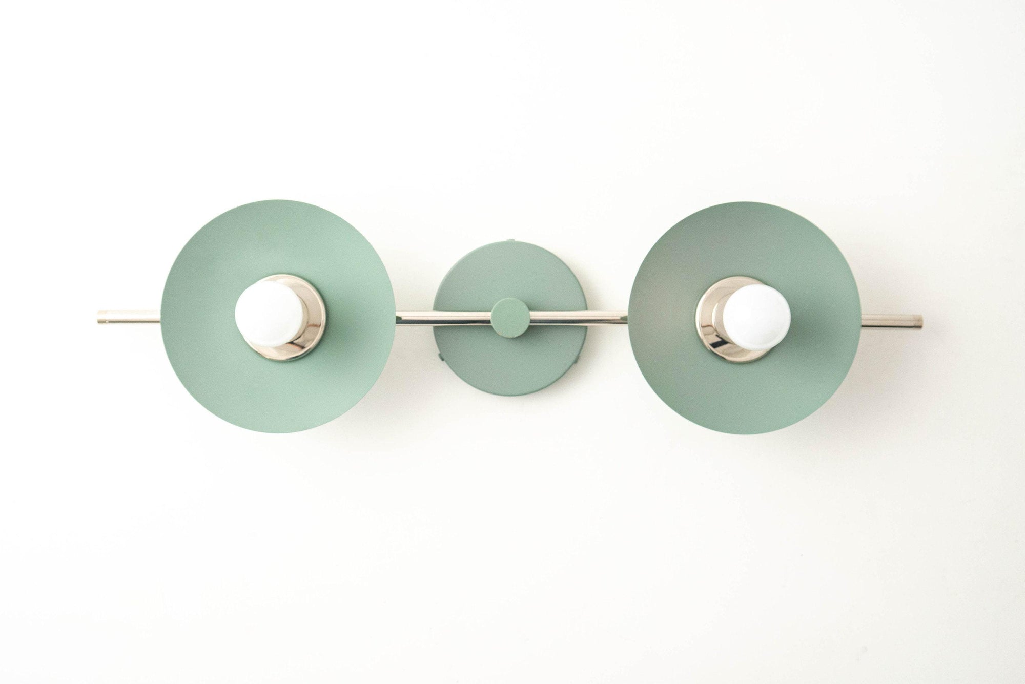 Art Deco vanity light with two green circular metal shades and a raw brass rod mount. - VANITY LIGHT MODEL NO. 8151