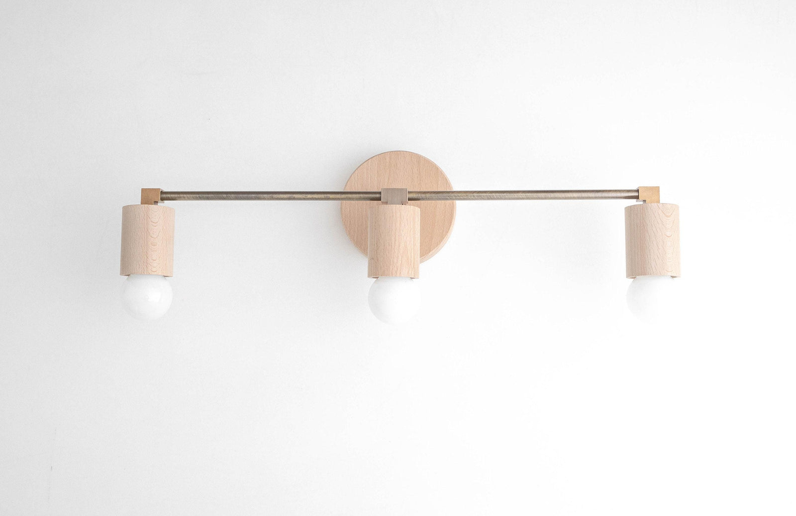 Three-bulb vanity light with natural beech wood and black metal rod mounted on white wall. - VANITY LIGHT MODEL NO. 4446