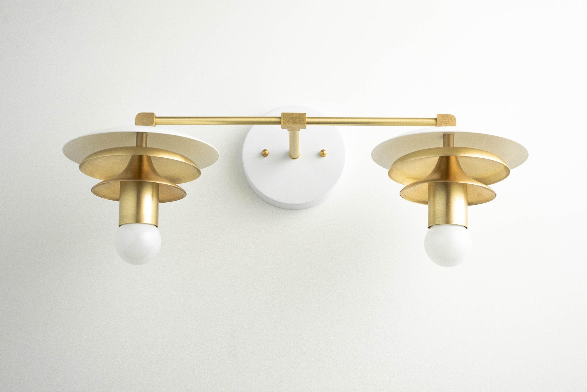 Raw brass two-bulb vanity light with Art Deco style shades on white wall mount. - VANITY LIGHT MODEL NO. 5806