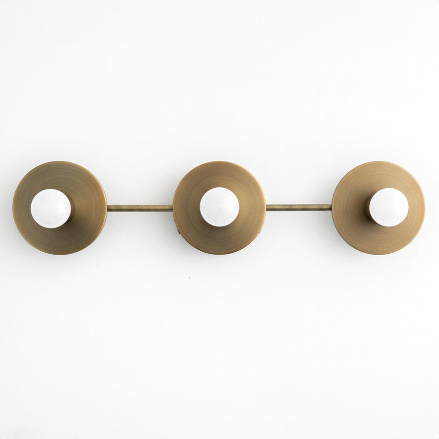 Three-bulb vanity light fixture in antique brass with round, dome-shaped shades and exposed bulbs. - VANITY LIGHT MODEL NO. 5708