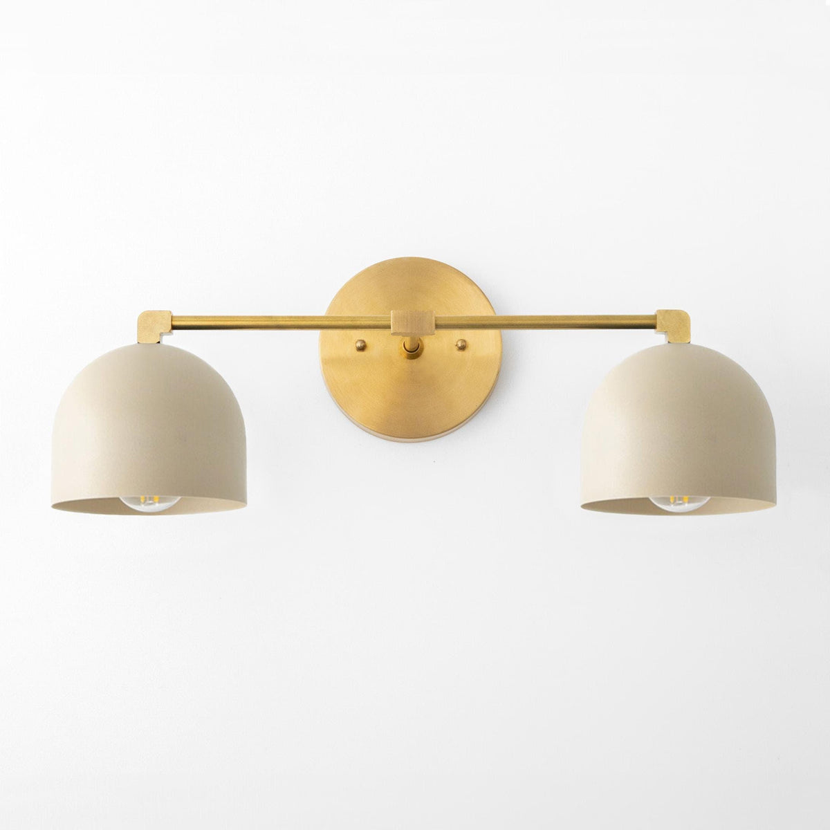 Antique brass vanity light with two cream dome shades and a round wall mount. - VANITY LIGHT MODEL NO. 0698