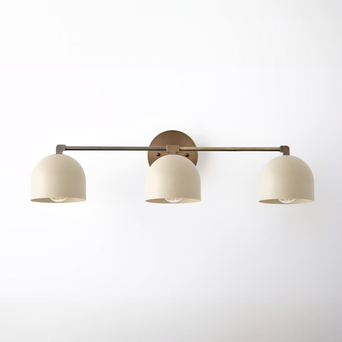 Three-bulb vanity light with brushed nickel finish and cream dome shades on a horizontal bar. - VANITY LIGHT MODEL NO. 7565