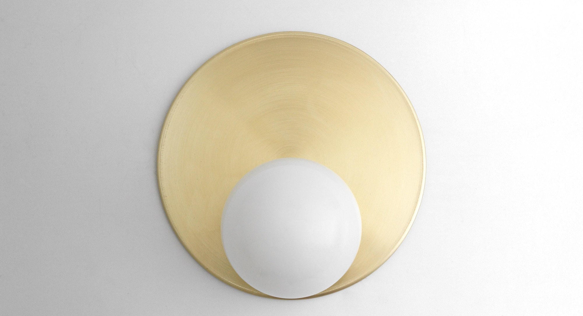 Mid-century modern wall sconce with a matte brass circular backplate and white glass globe shade. - SCONCE MODEL NO. 6703