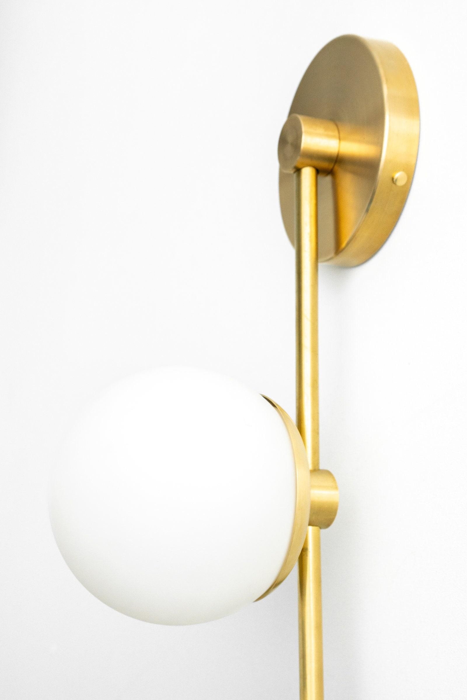 Antique brass wall sconce with frosted white glass globe and slim vertical arm. - SCONCE MODEL NO. 0344