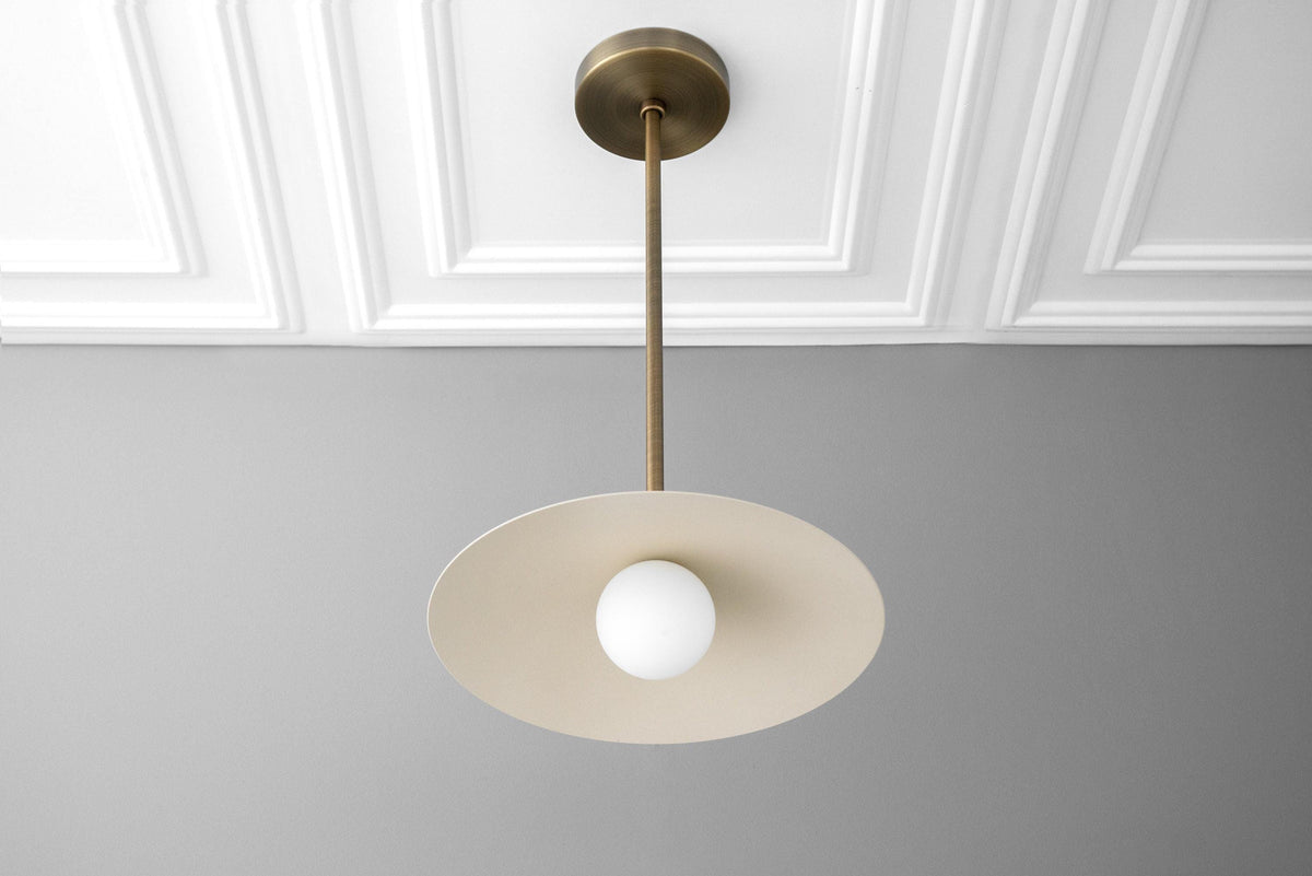 Antique brass pendant with shallow cream globe shade and round white bulb centerpiece. - PENDANT MODEL NO. 4085