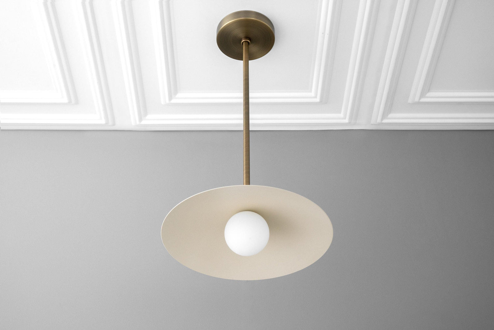 Antique brass pendant with shallow cream globe shade and round white bulb centerpiece. - PENDANT MODEL NO. 4085