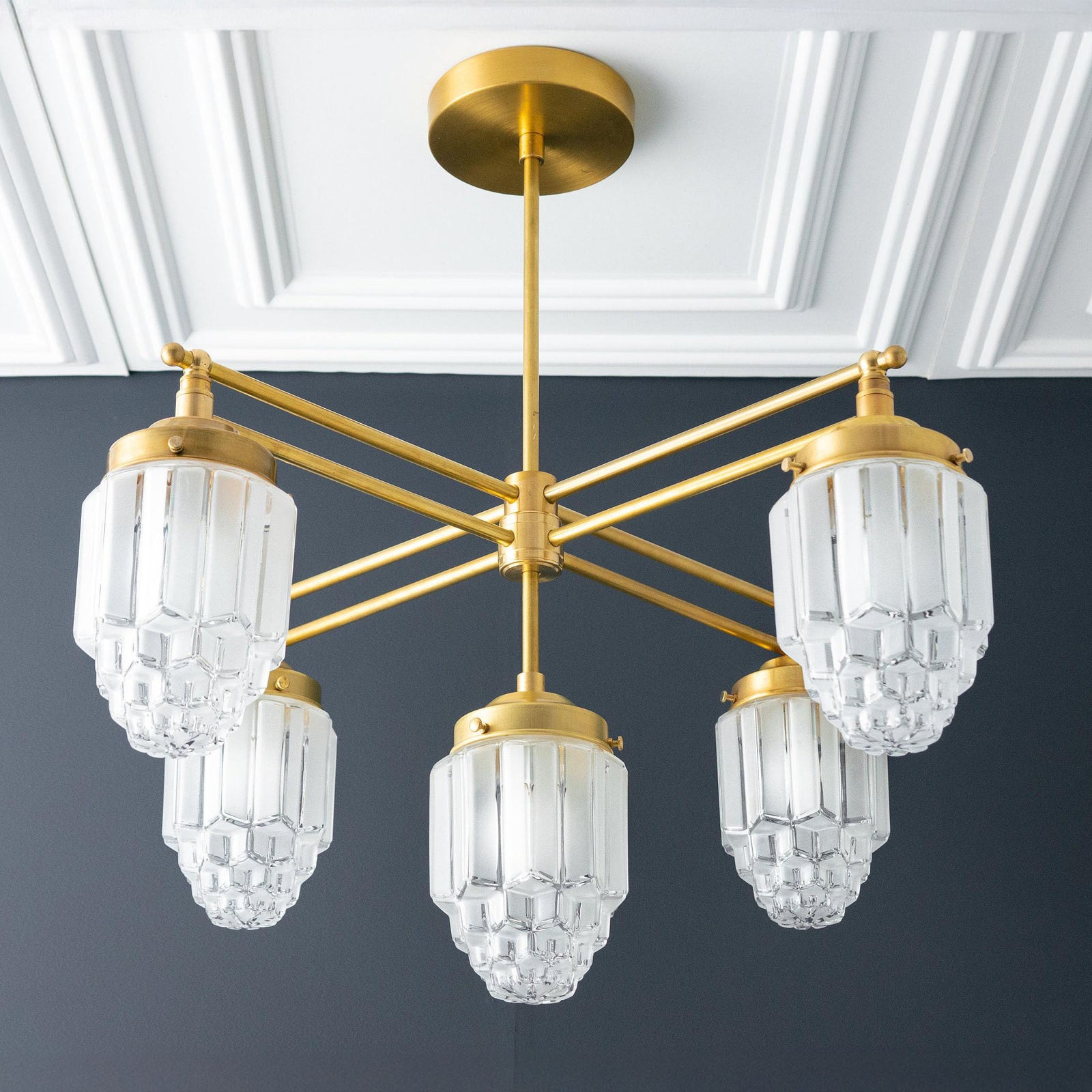 Raw brass Art Deco chandelier with five tiered globe glass shades and geometric arms. - CHANDELIER MODEL NO. 5830