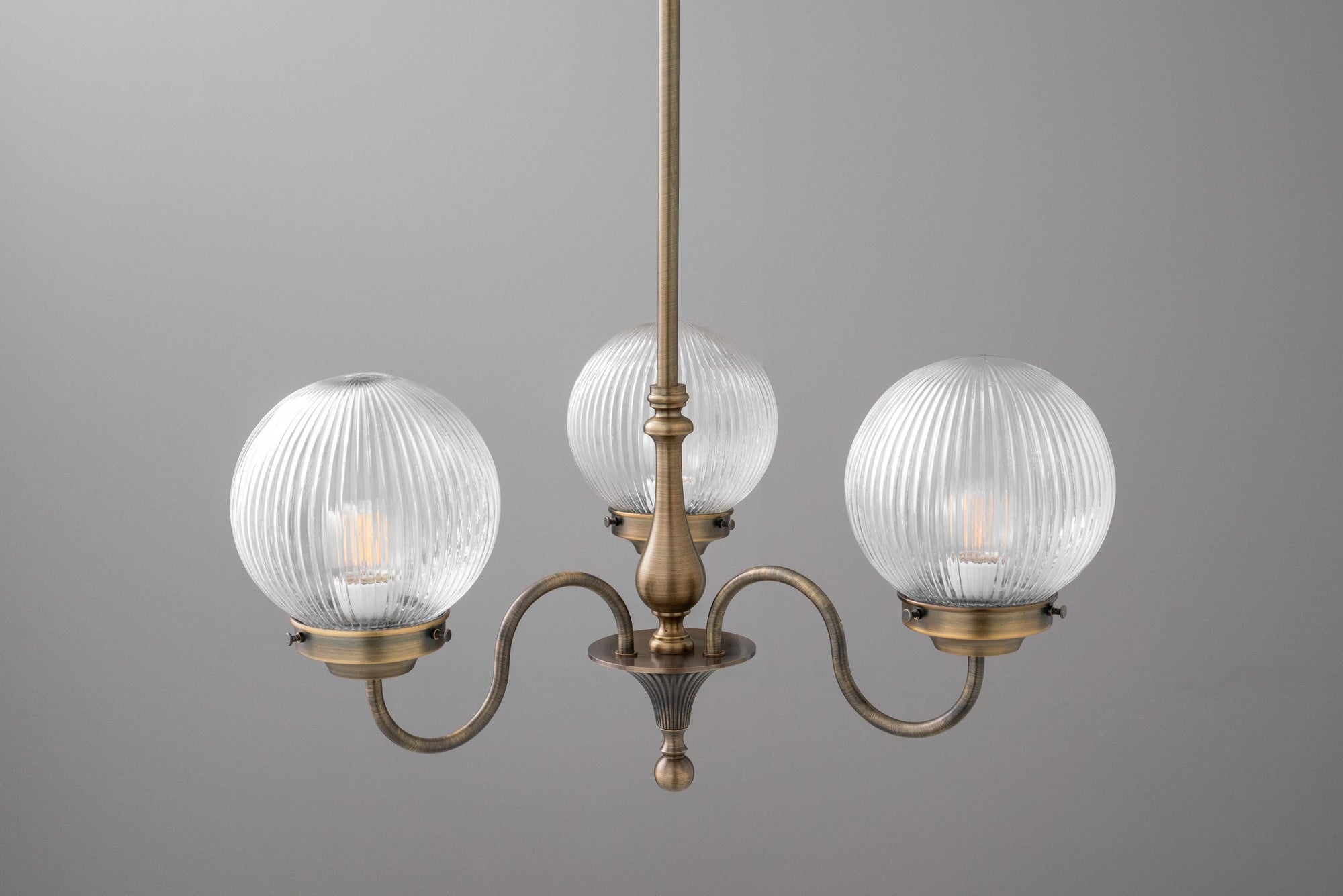 Antique brass chandelier with three ribbed glass globe shades and curved arms. - CHANDELIER MODEL NO. 2894