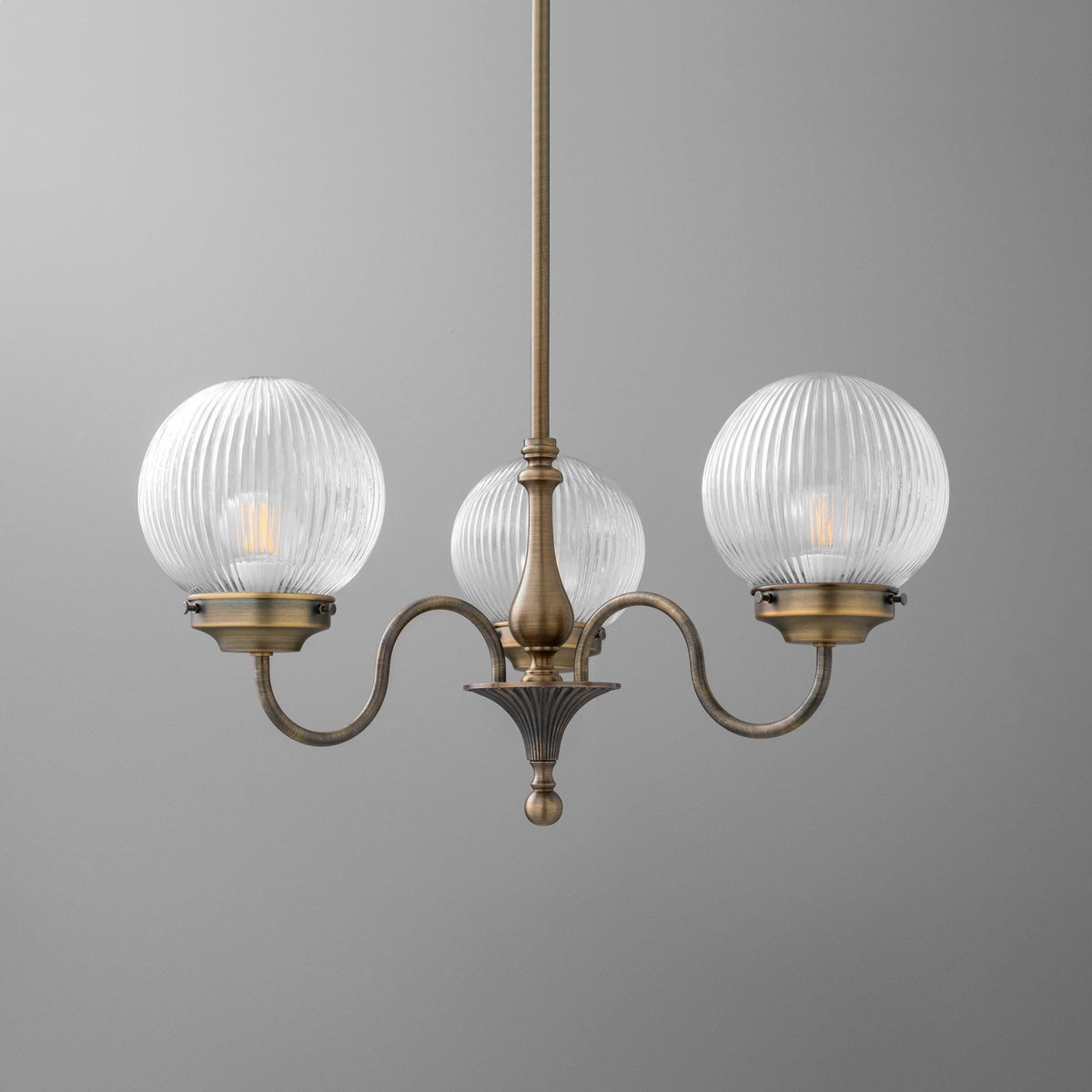 Three-light antique brass chandelier with ribbed clear glass globe shades and curving arms. - CHANDELIER MODEL NO. 2894