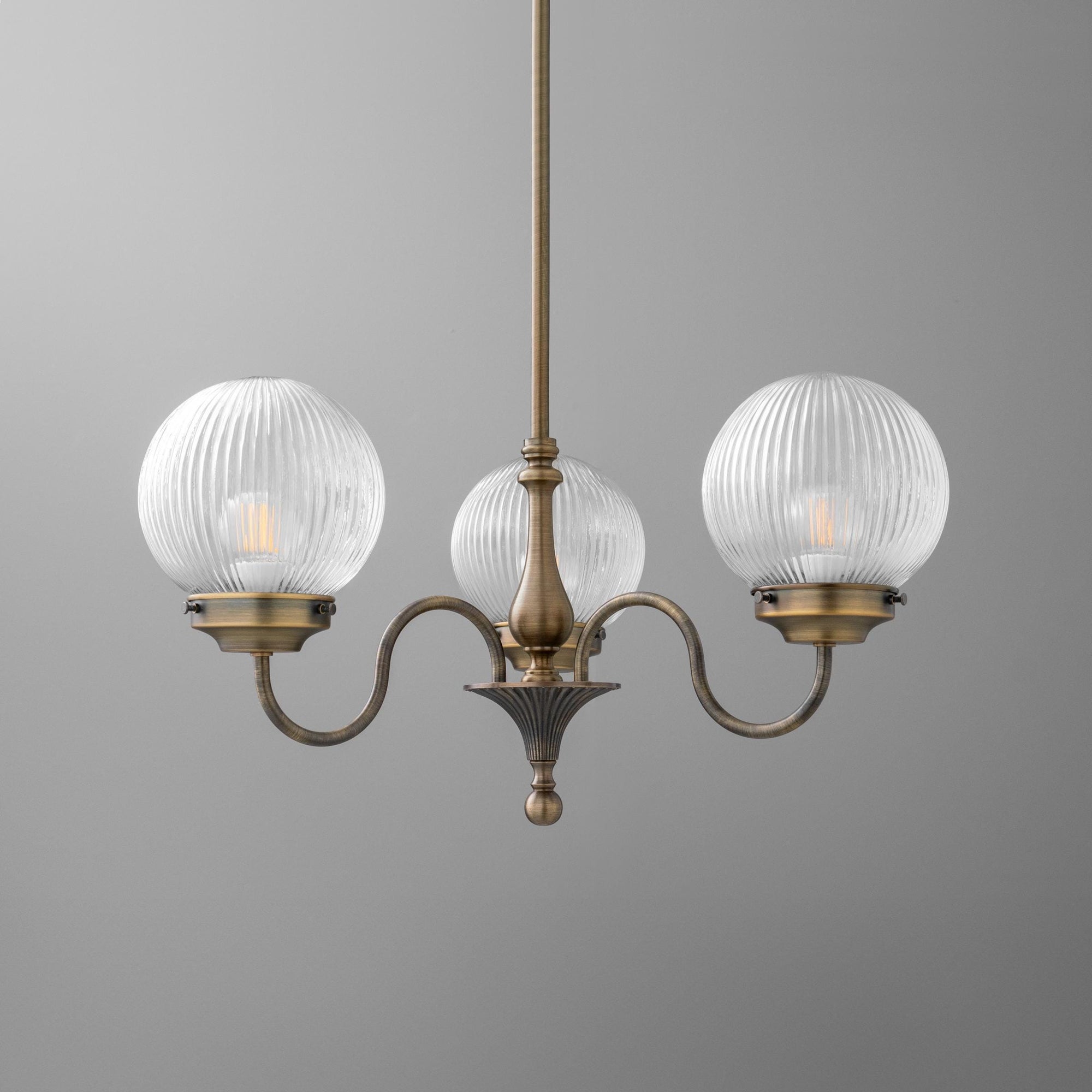 Three-light antique brass chandelier with ribbed clear glass globe shades and curving arms. - CHANDELIER MODEL NO. 2894