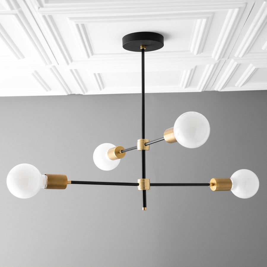 Art Deco chandelier with four white globe bulbs on black rods and brass connectors suspended from black ceiling mount. - CHANDELIER MODEL NO. 5598