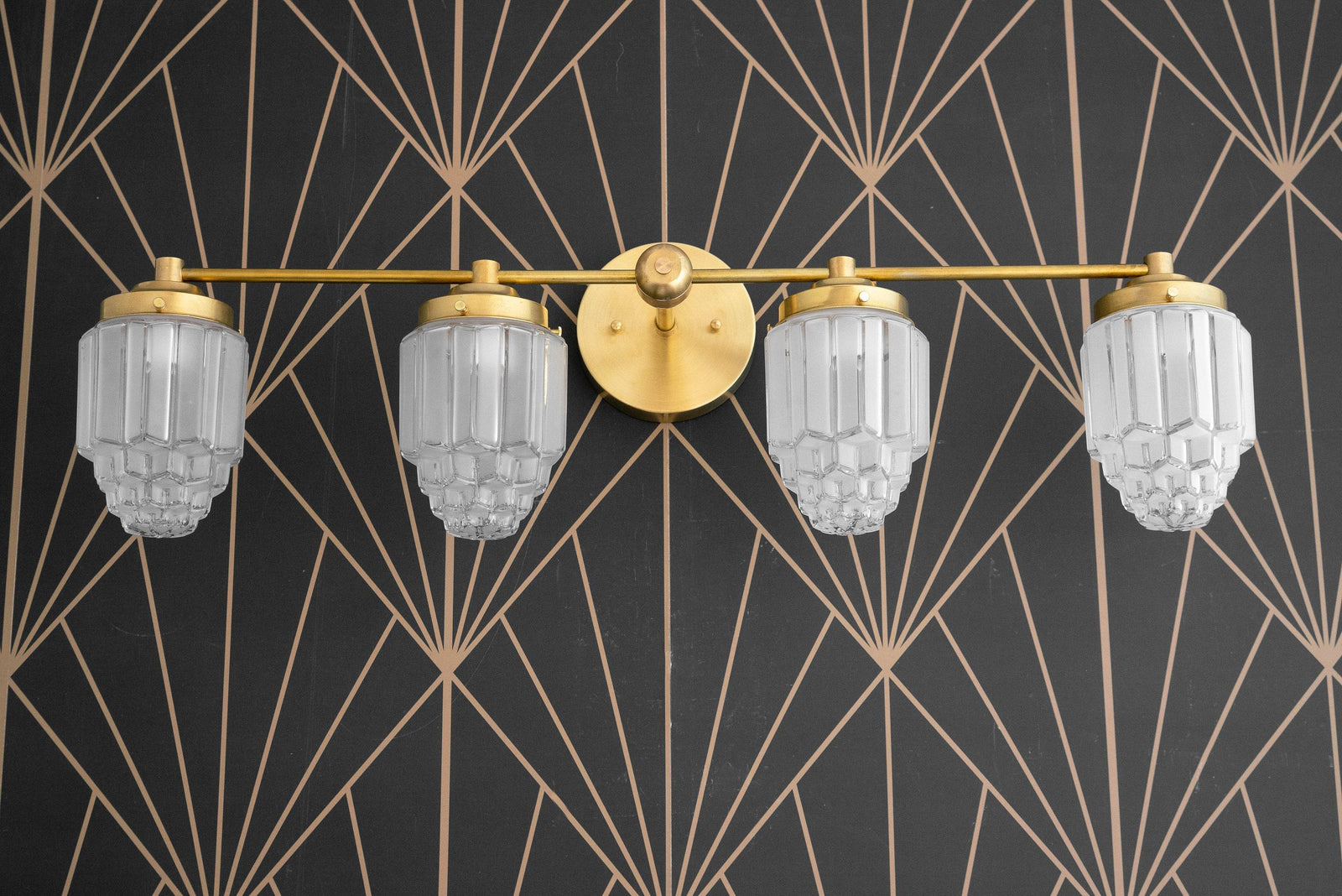 Art Deco 4-bulb vanity light with polished brass finish and geometric clear glass globes against black and gold patterned. - VANITY LIGHT MODEL NO. 1082
