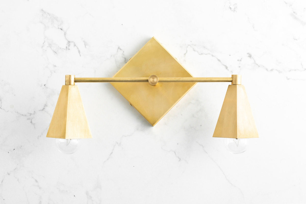 Art Deco 2-bulb vanity light in raw brass with geometric diamond backplate and tapered shades. - VANITY LIGHT MODEL NO. 4237