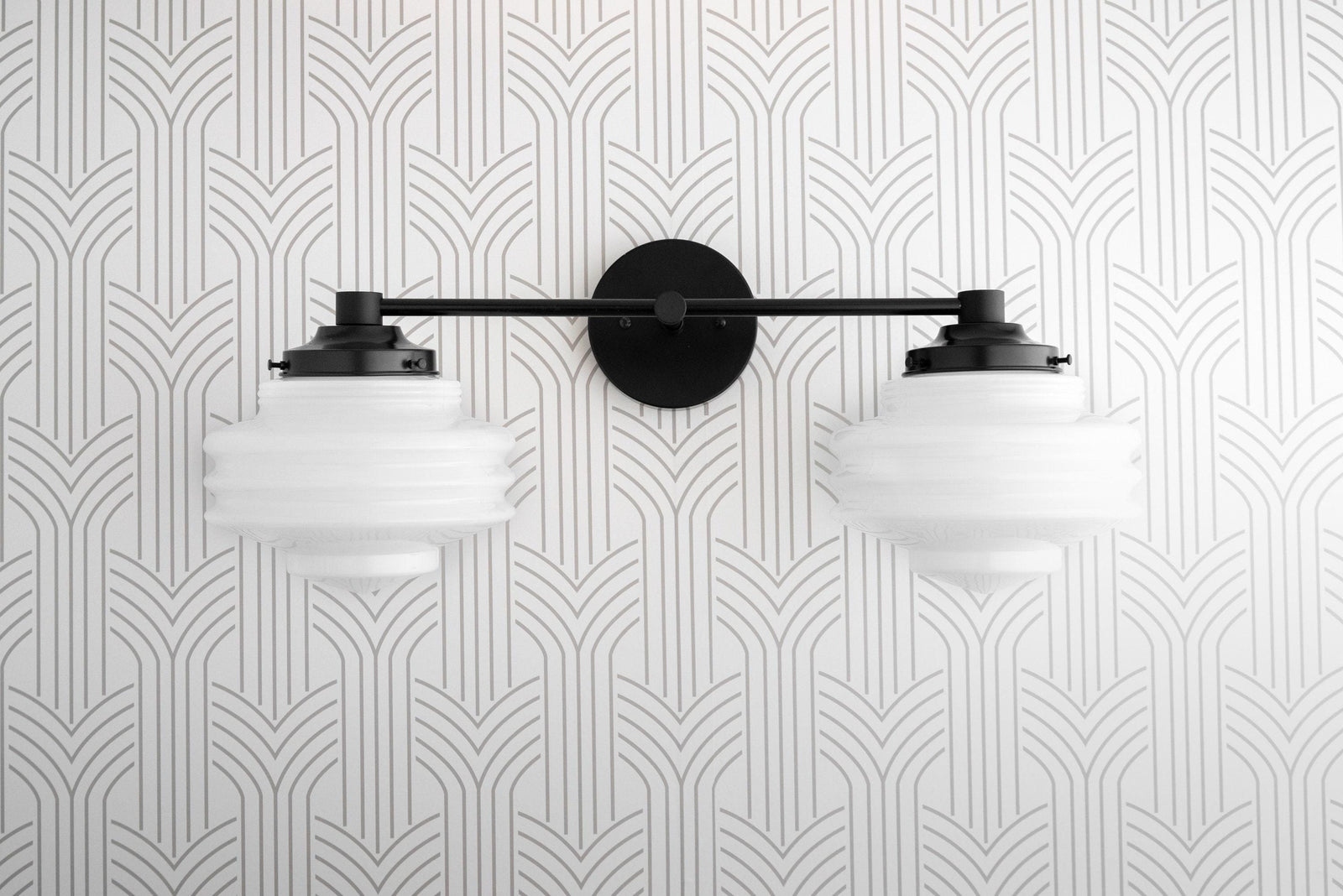 Black two-bulb vanity light with art deco ribbed globe shades mounted on a geometric patterned wall. - VANITY LIGHT MODEL NO. 9479