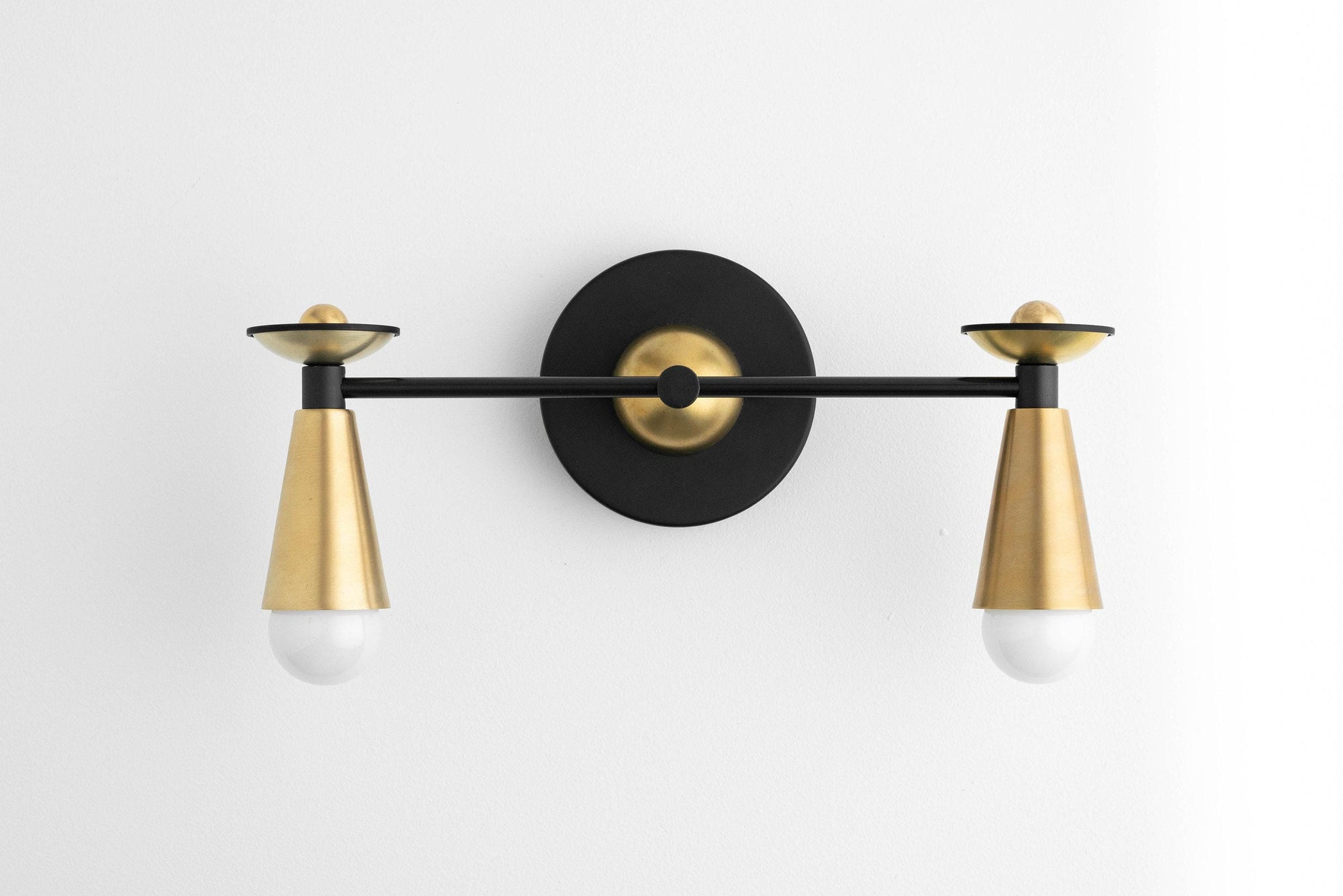 Art Deco two-bulb vanity light with black round backplate and raw brass cone shades. - VANITY LIGHT MODEL NO. 4517