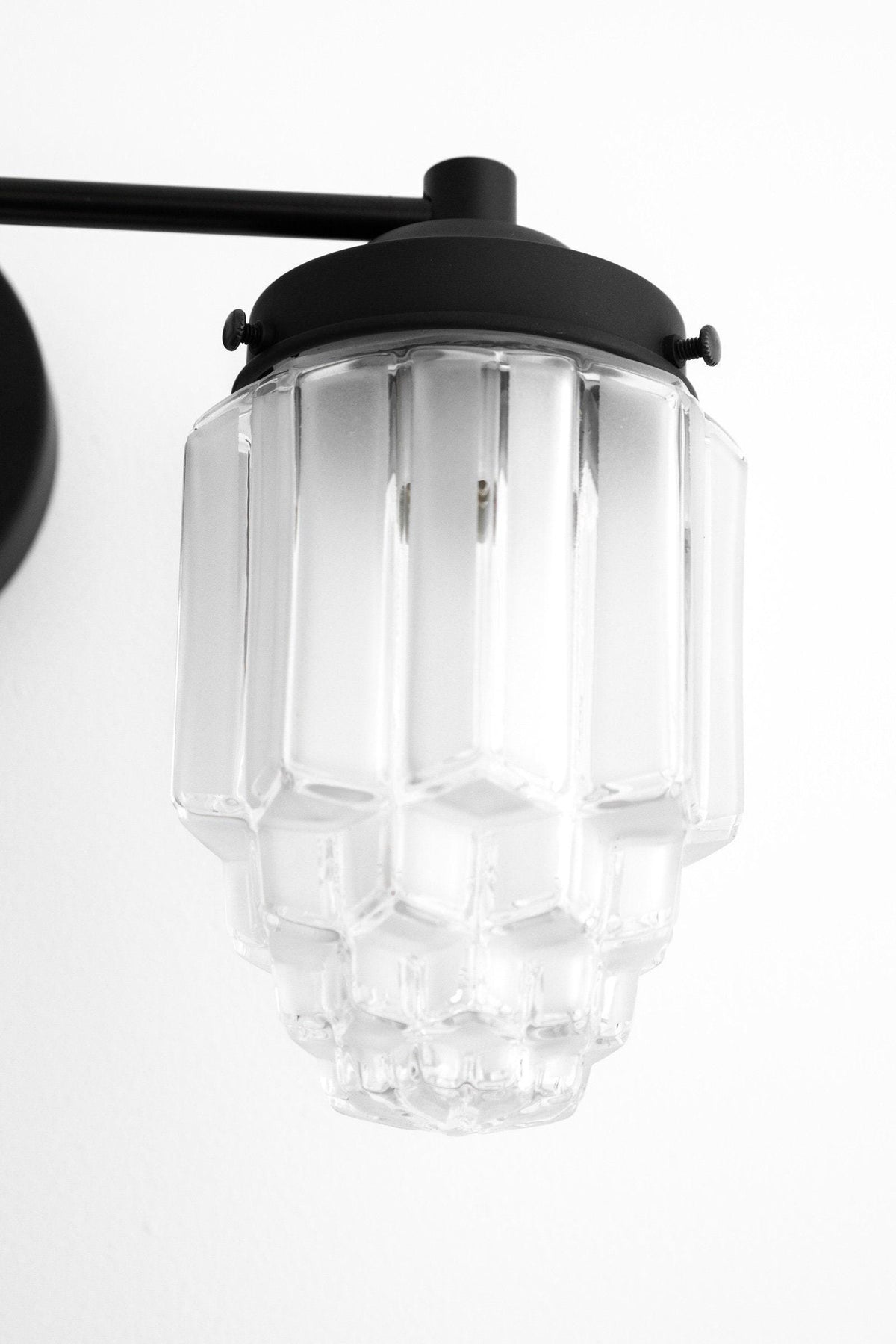 Black metal vanity light with clear geometric glass globe shade and two-bulb fixture. - VANITY LIGHT MODEL NO. 9777
