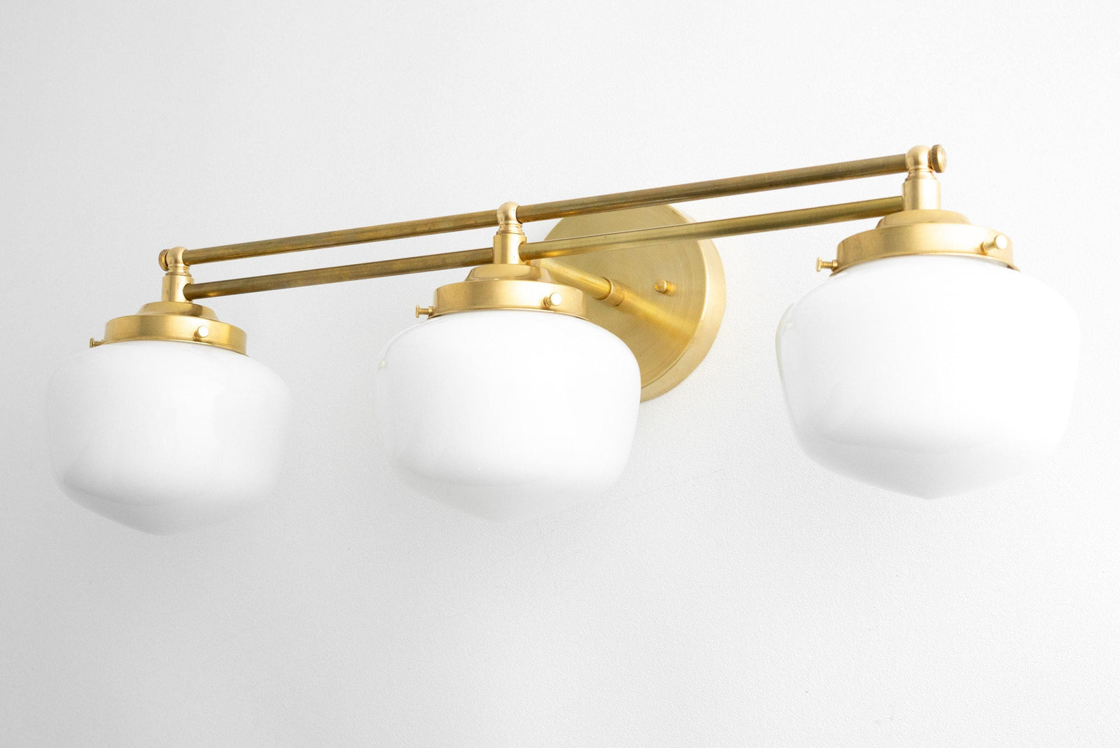 Three-bulb vanity light with polished brass finish and white globe shades in Art Deco style. - VANITY LIGHT MODEL NO. 4352
