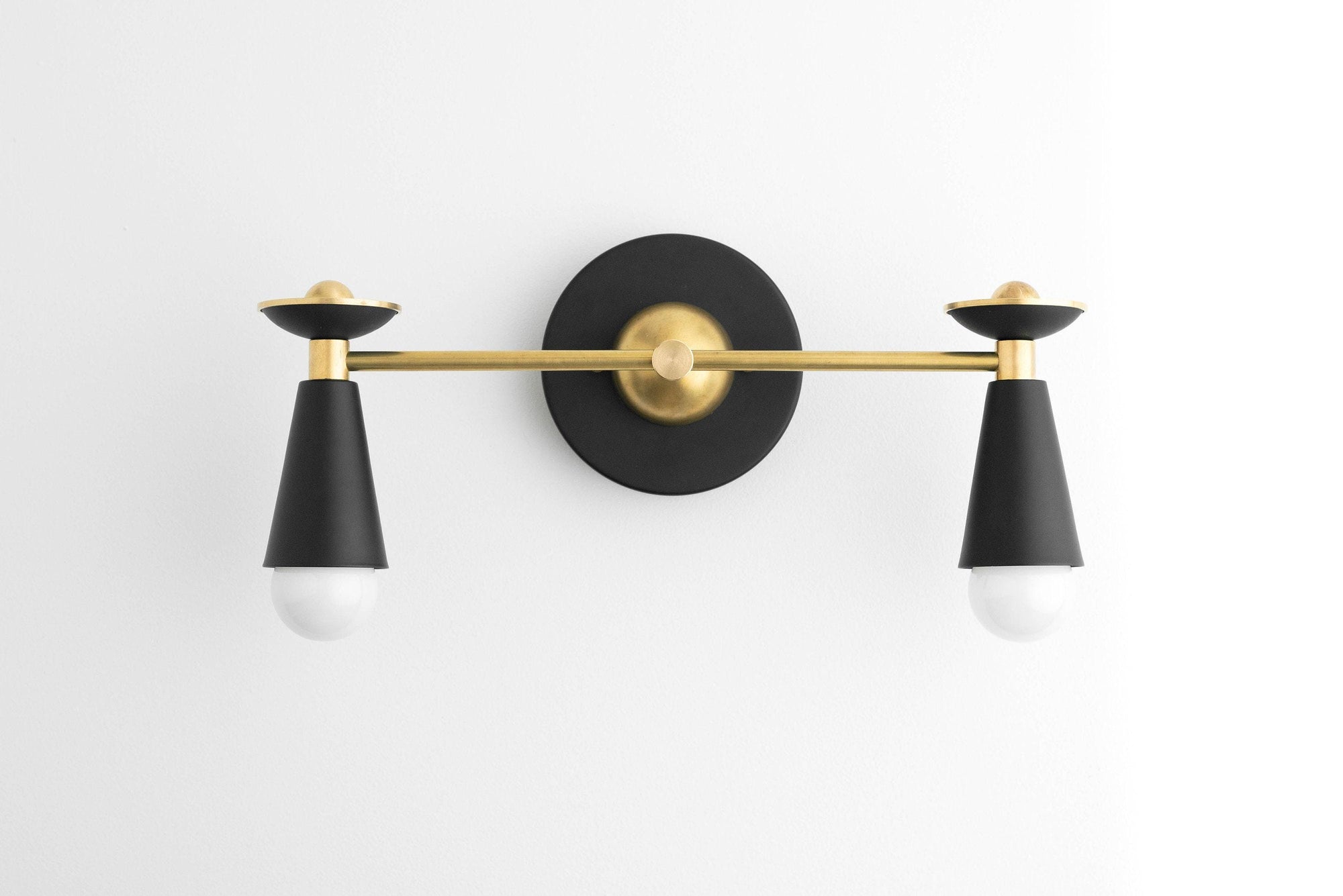 Art Deco vanity light with two bare bulbs, black conical shades, and brass accents. - VANITY LIGHT MODEL NO. 4517