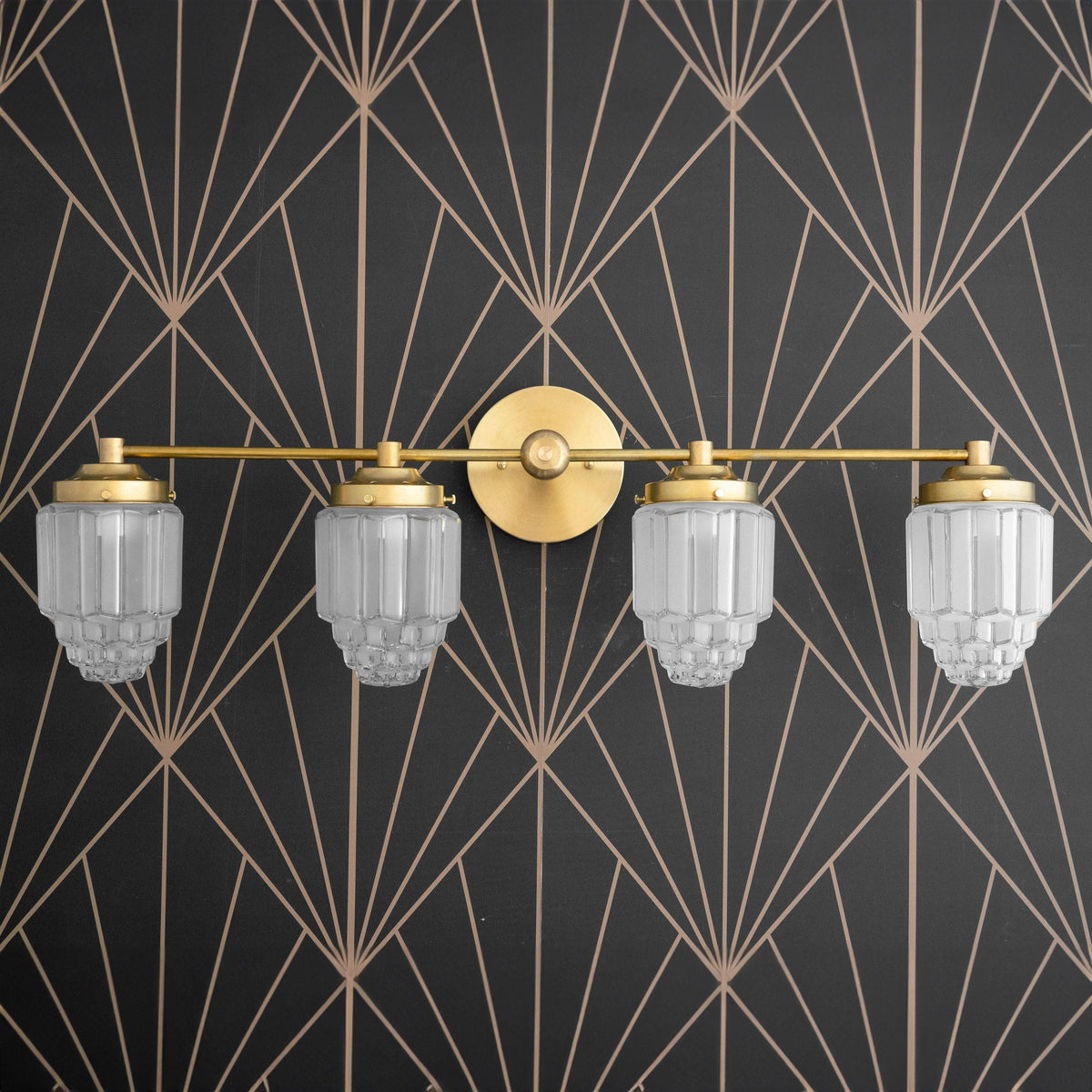 Art Deco four-bulb vanity light fixture in raw brass with etched globe shades against geometric wallpaper. - VANITY LIGHT MODEL NO. 1082
