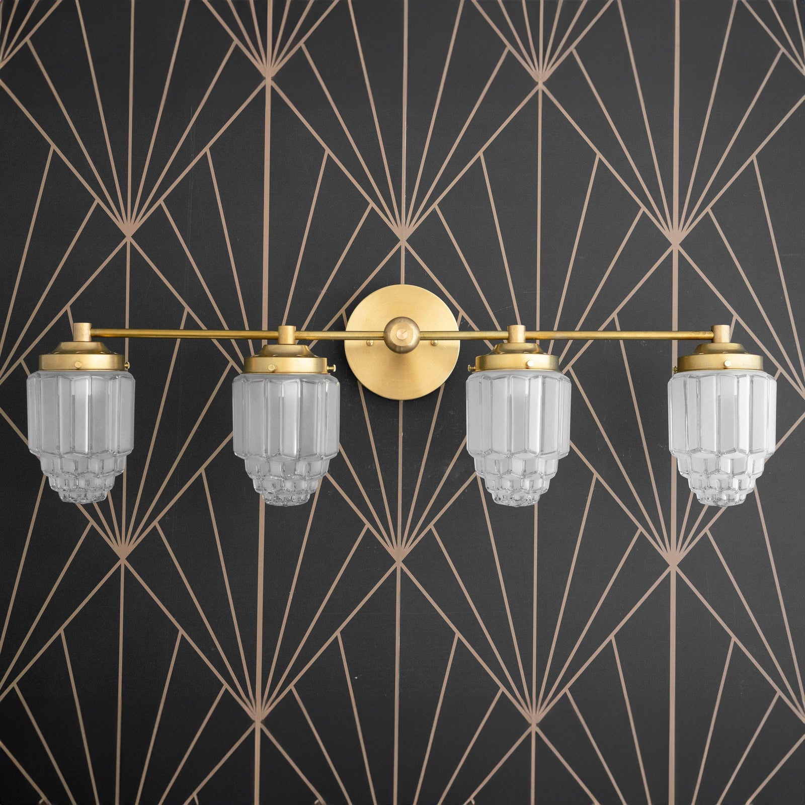 Art Deco four-bulb vanity light fixture in raw brass with etched globe shades against geometric wallpaper. - VANITY LIGHT MODEL NO. 1082