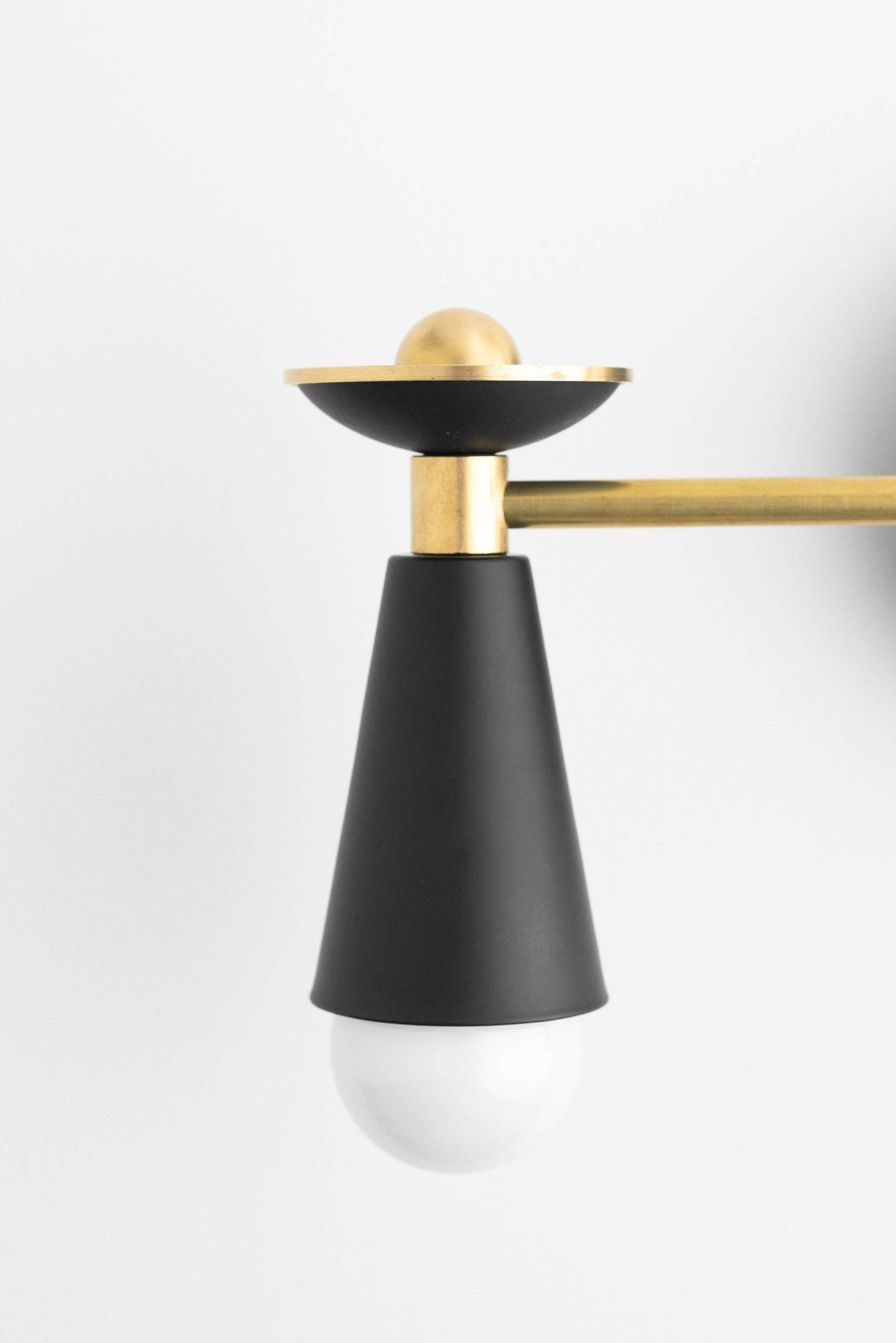 Art Deco black and brass vanity light with tapered metal shade and exposed bulb. - VANITY LIGHT MODEL NO. 4517