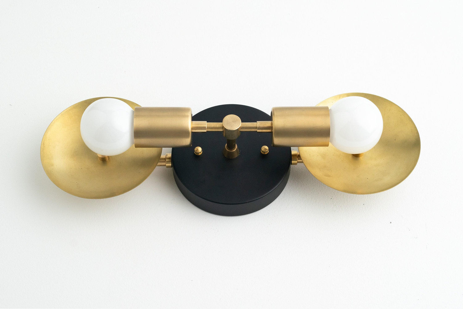 Art Deco 2-bulb vanity light with raw brass finish and black circular mounting plate. - VANITY LIGHT MODEL NO. 2945