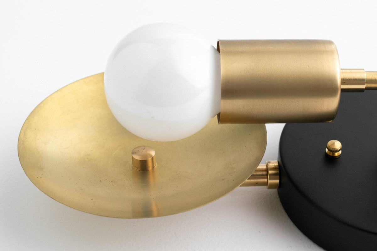 Mid-century modern vanity light with two round white bulbs, brass and black metal accents. - VANITY LIGHT MODEL NO. 2945