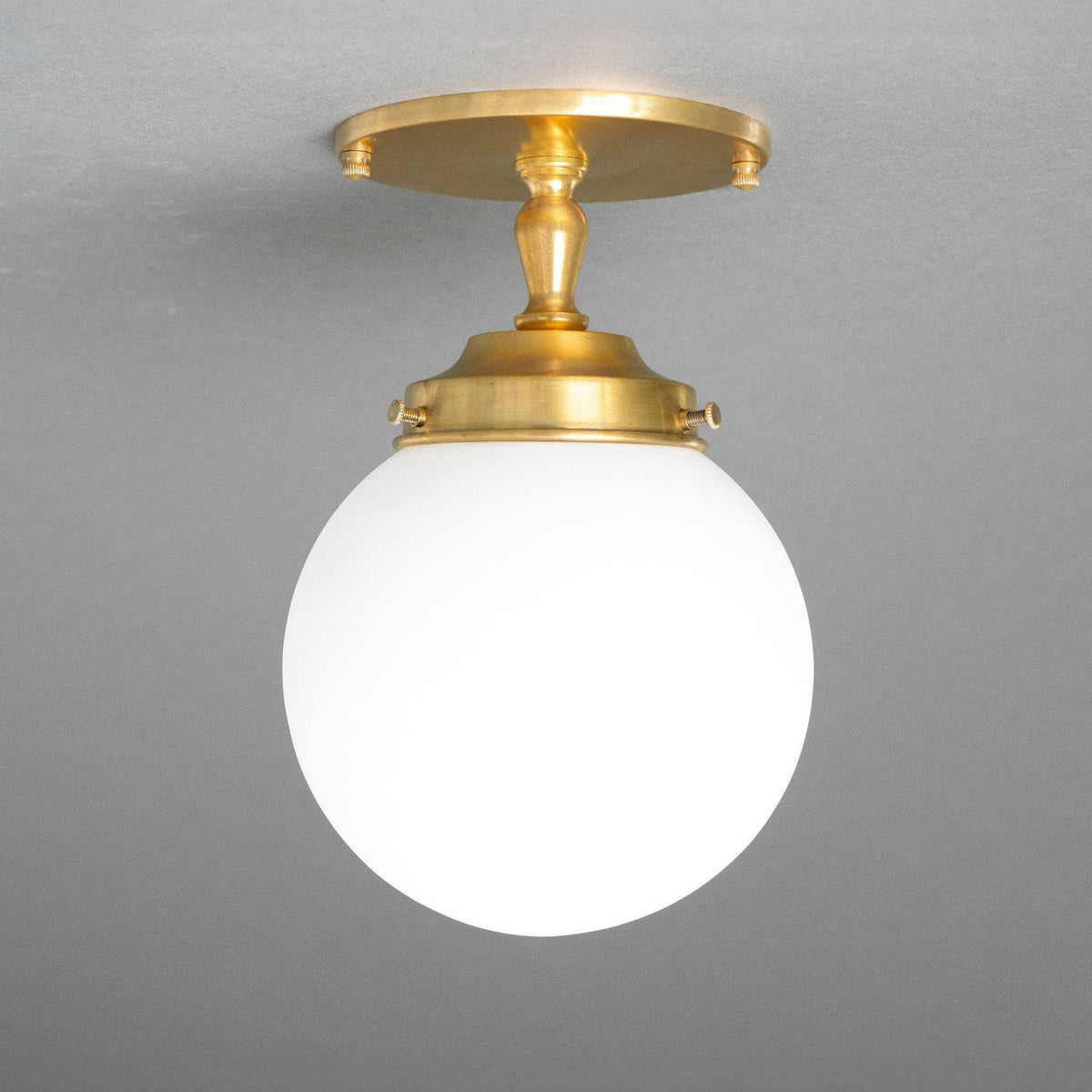 Flush ceiling light in Raw or Sealed Brass with a turned stem and an opal glass globe shade. - CEILING LIGHT MODEL NO. 0220