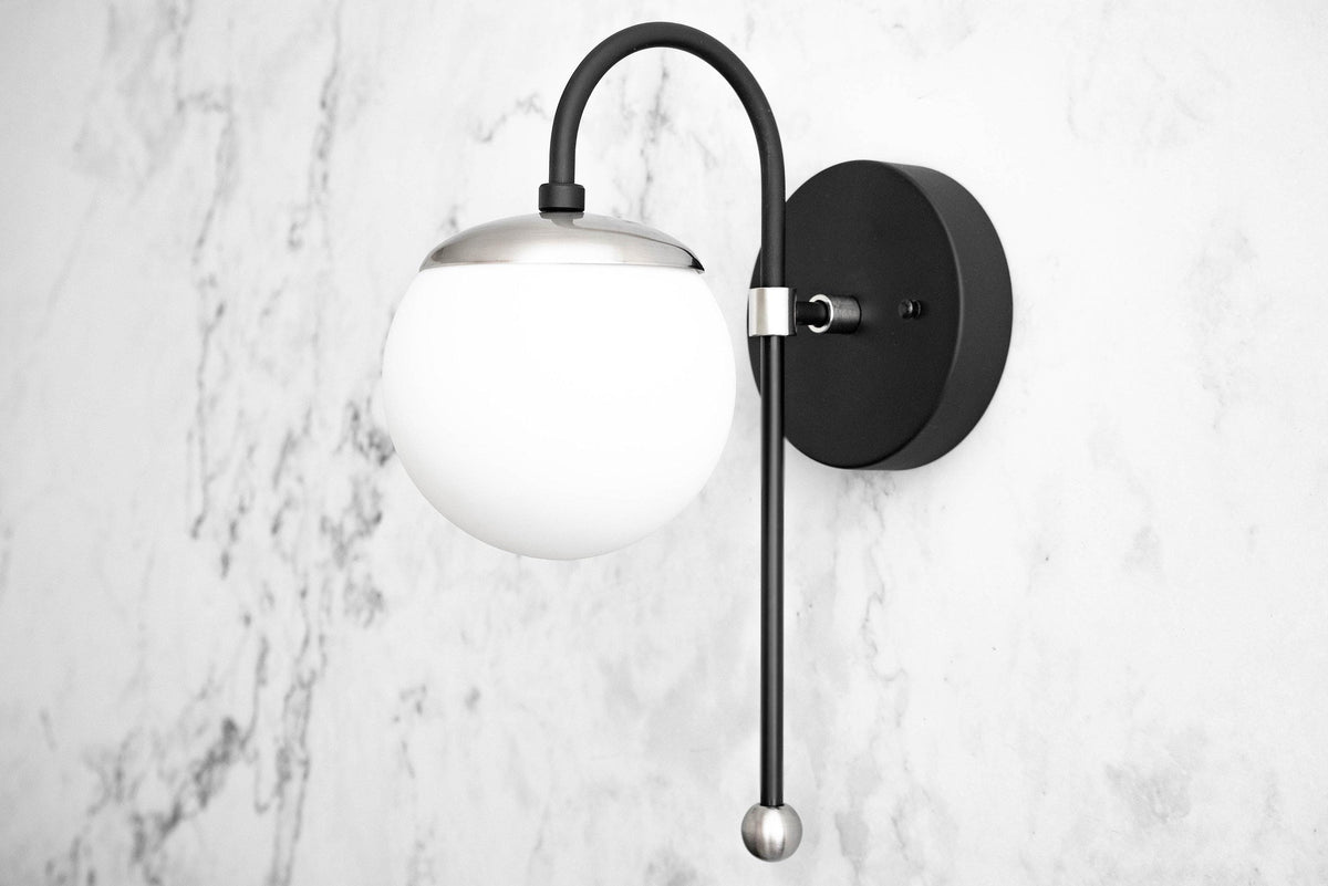 Art Deco semi-flush black sconce with white glass globe and curved arm on marble wall. - SCONCE MODEL NO. 1045