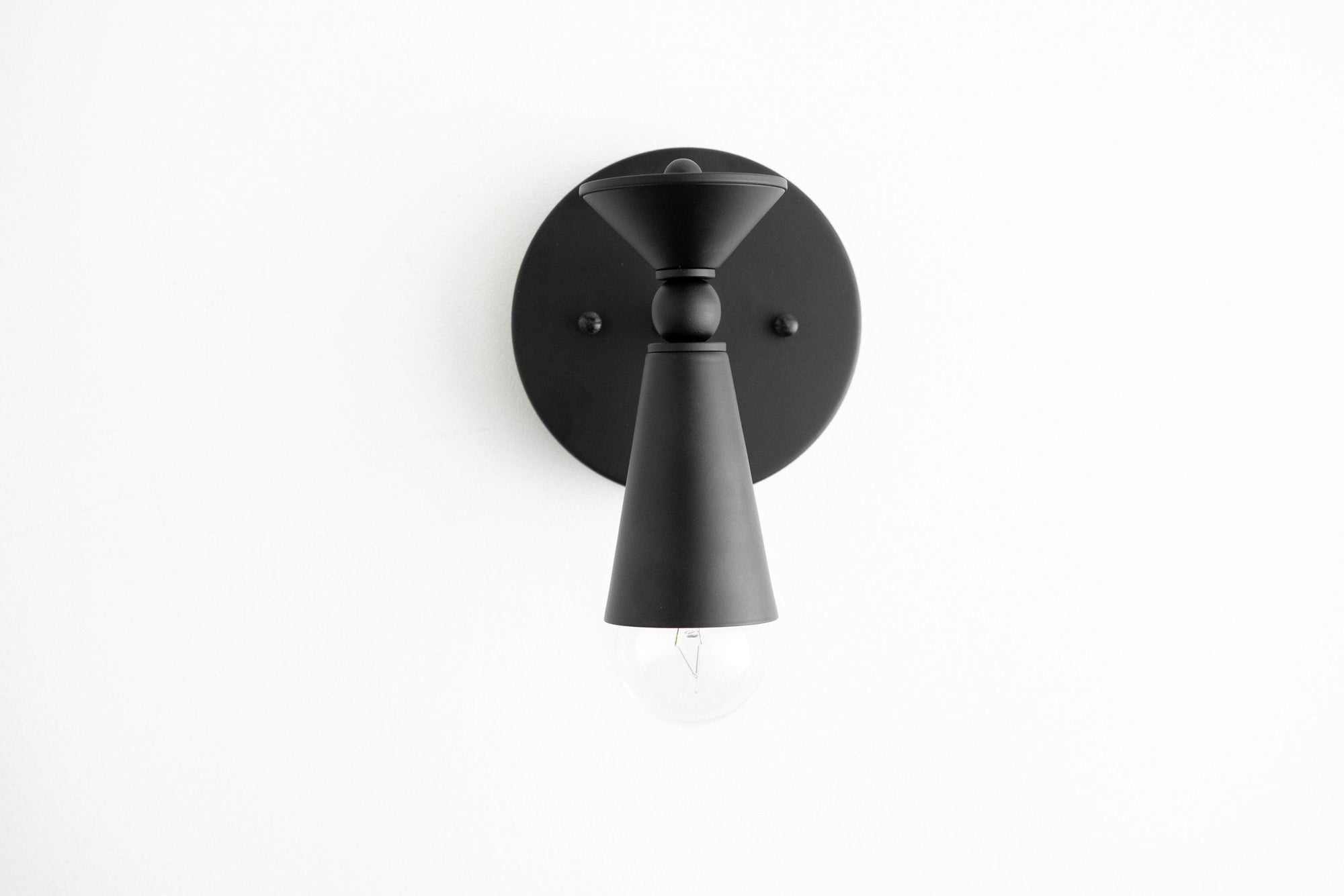 Black matte metal wall sconce with conical shade and exposed bulb design. - SCONCE MODEL NO. 8393