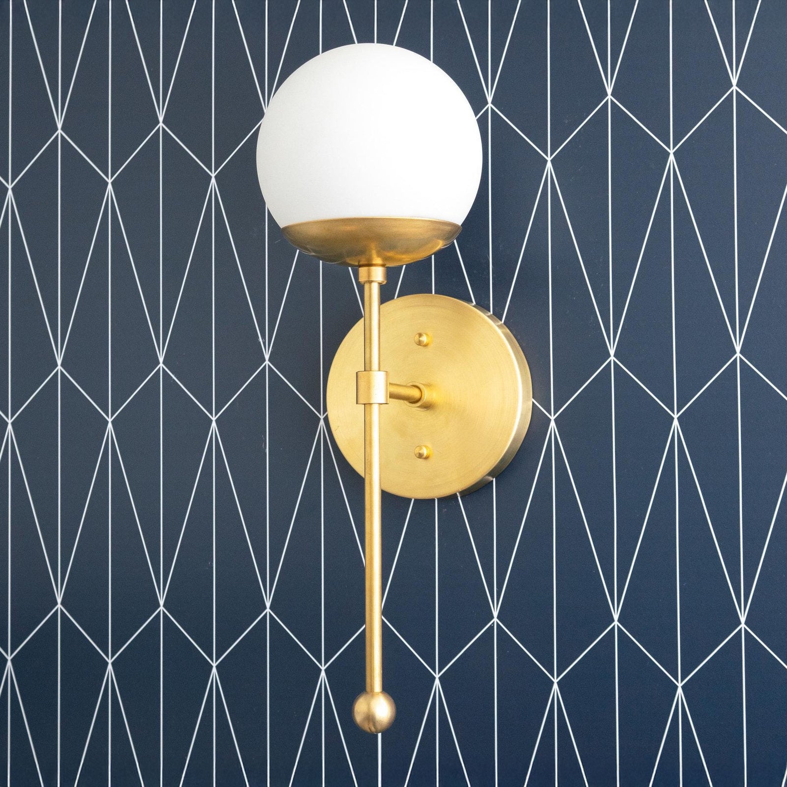 Art Deco semi-flush wall sconce with brass finish and white globe shade on geometric navy wallpaper background. - SCONCE MODEL NO. 1048