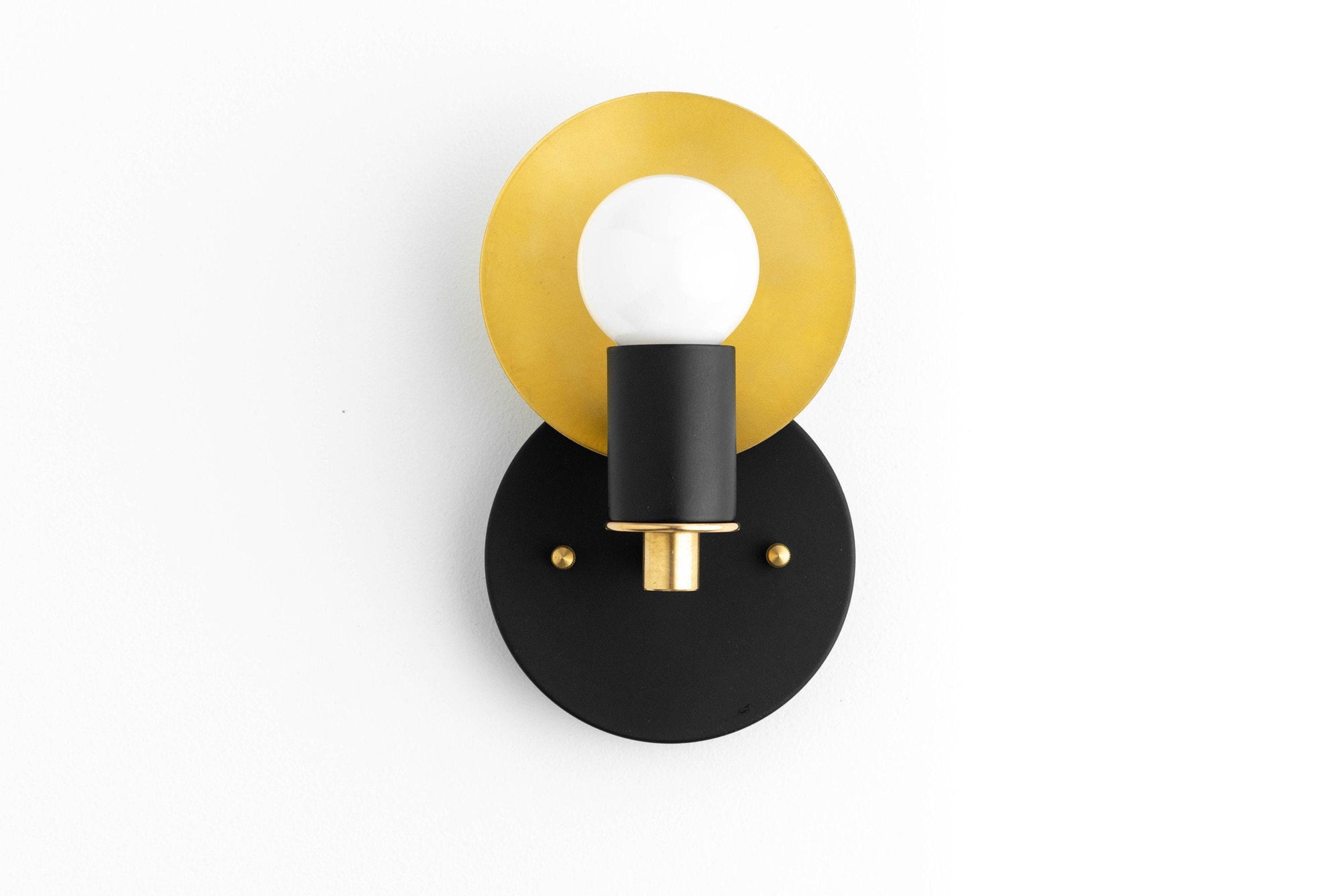Black and brass Art Deco wall sconce with round backplate and exposed bulb. - SCONCE MODEL NO. 8677