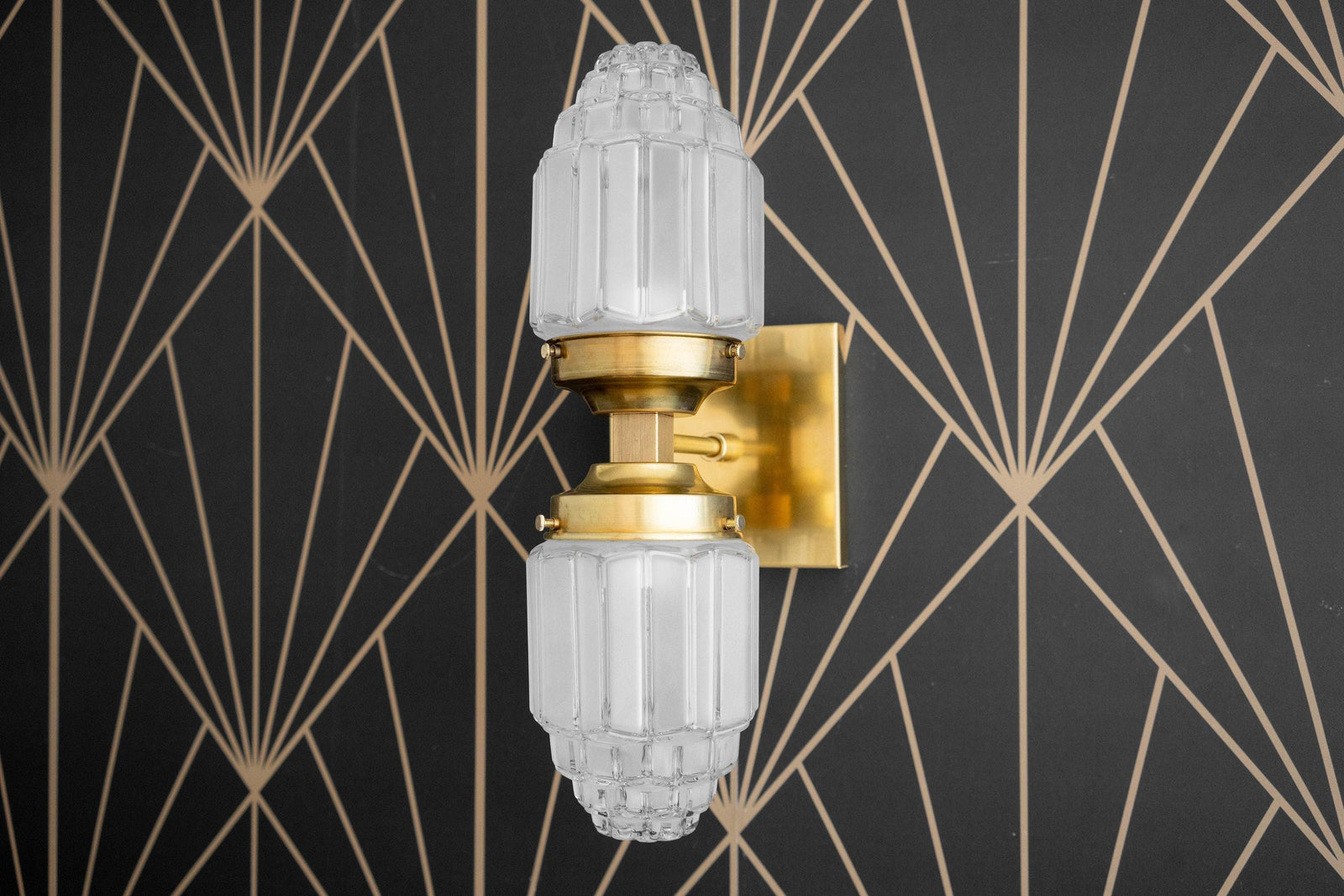 Art Deco raw brass wall sconce with two faceted glass globes and geometric backplate. - SCONCE MODEL NO. 7180