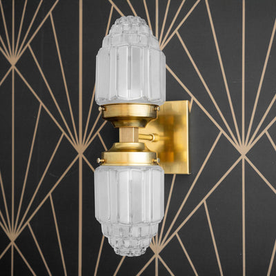 Art Deco double globe sconce in raw brass with textured glass shades and rectangular wall plate. - SCONCE MODEL NO. 7180