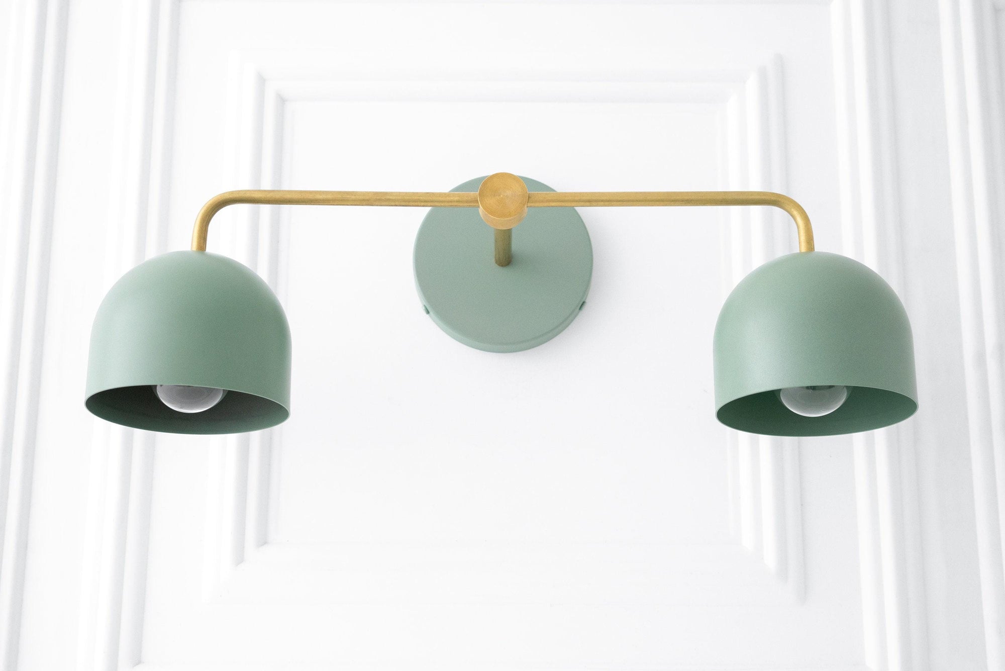 Mid-century modern vanity light with raw brass arm and two matte green dome shades. - VANITY LIGHT MODEL NO. 2082