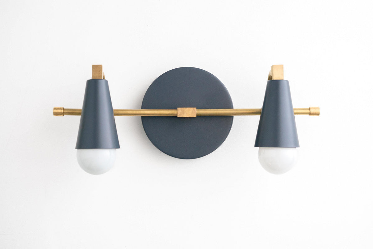 Mid-century modern vanity light with two coal blue conical shades and raw brass accents on a round black wall plate. - VANITY LIGHT MODEL NO. 1229