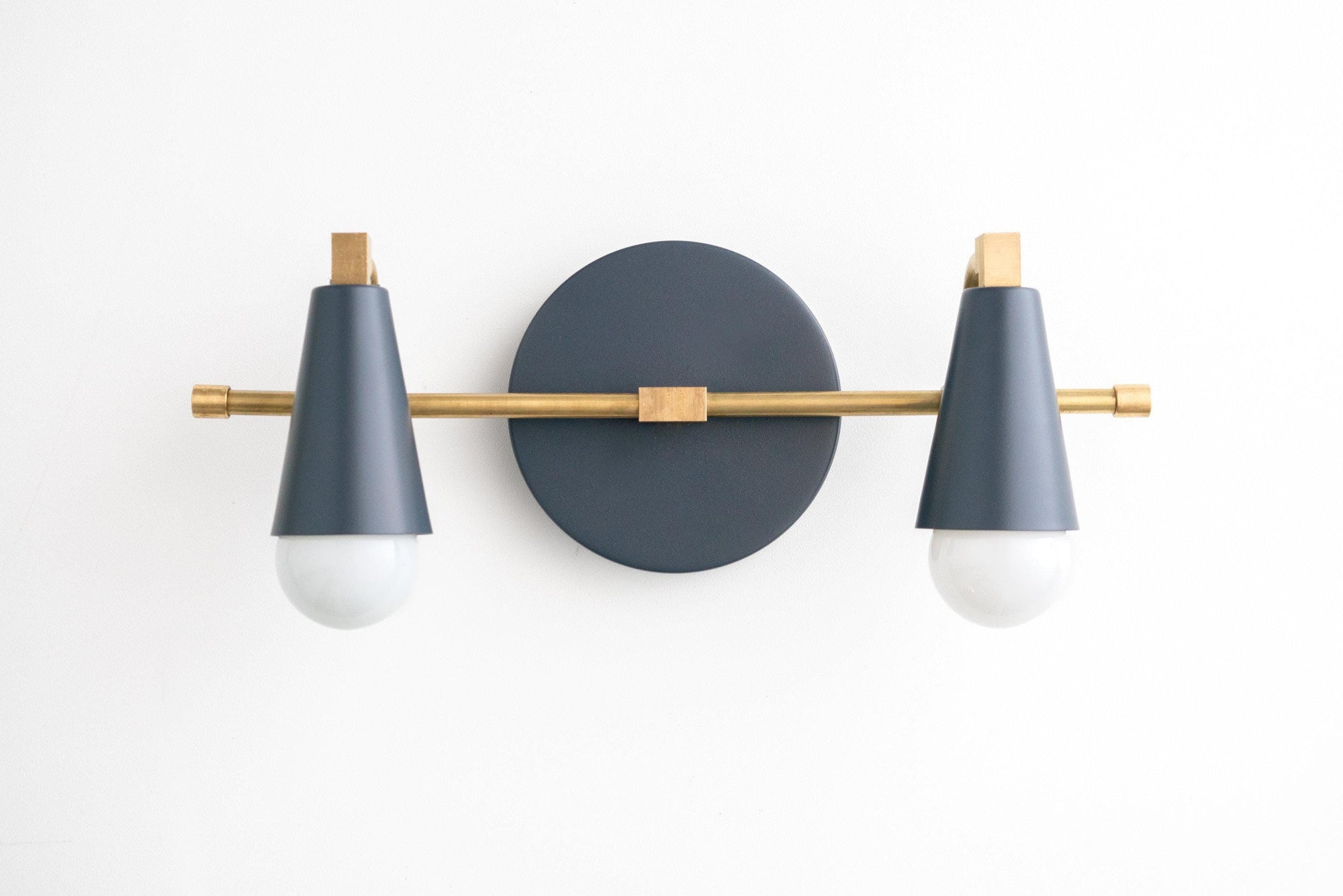 Mid-century modern vanity light with two coal blue conical shades and raw brass accents on a round black wall plate. - VANITY LIGHT MODEL NO. 1229