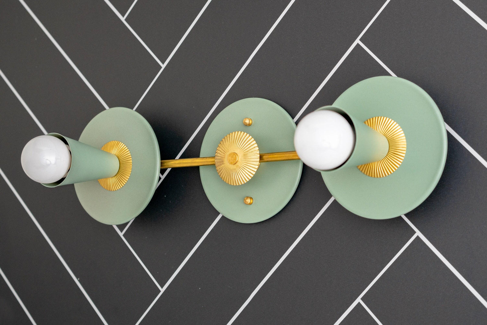 Art Deco raw brass vanity light with two exposed bulbs and green circular backplates on dark tile wall. - VANITY LIGHT MODEL NO. 4473