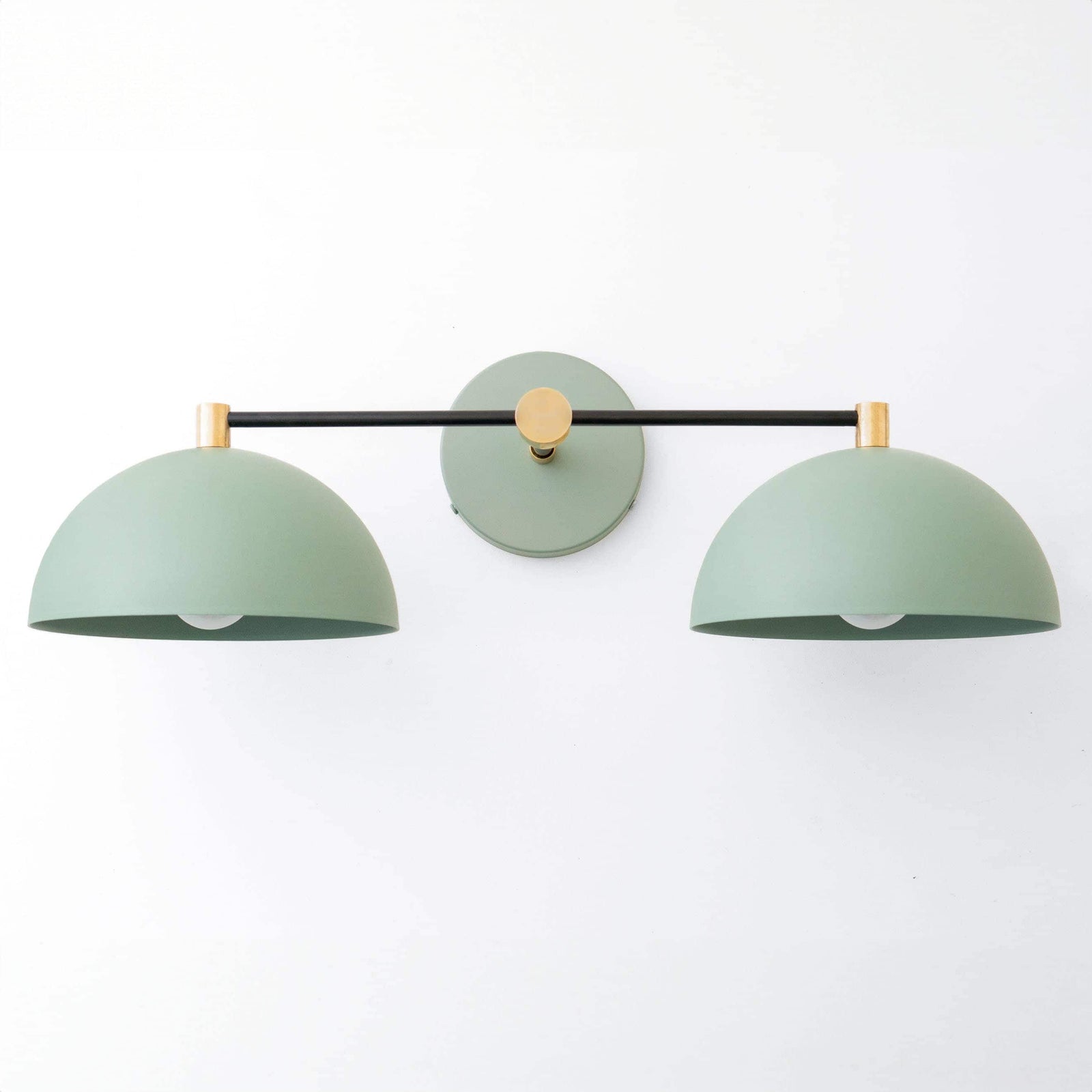 Art Deco vanity light with two matte green dome shades and black and brass metal accents. - VANITY LIGHT MODEL NO. 1027
