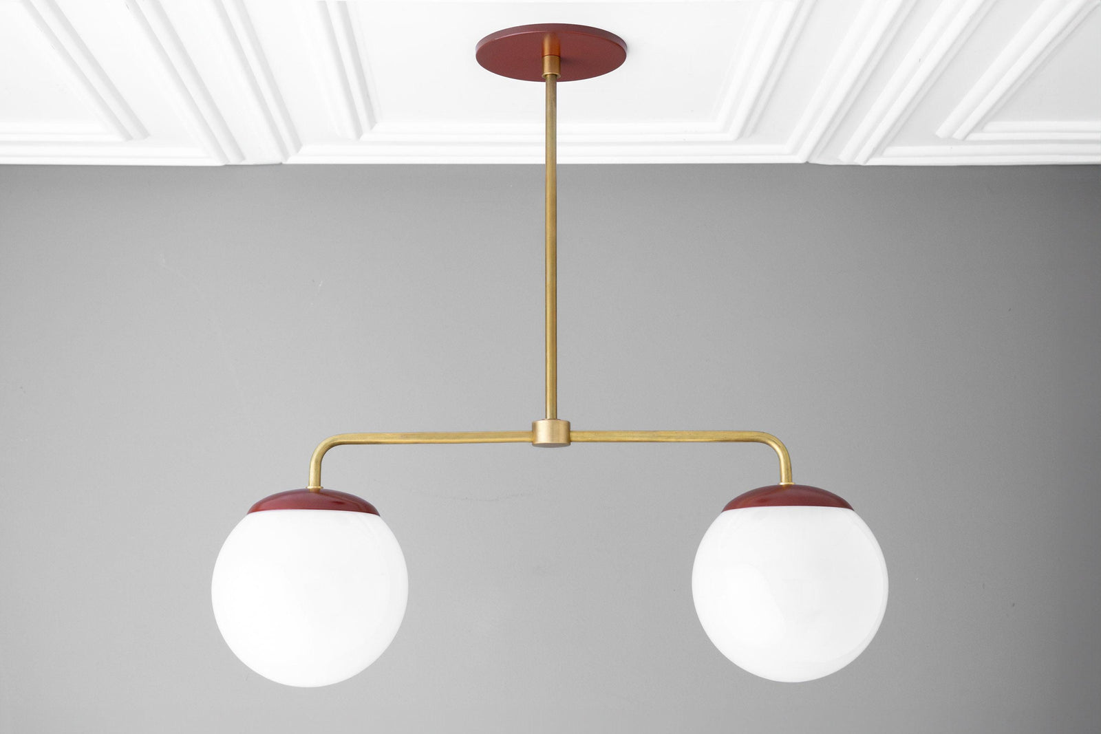 Mid-century modern chandelier with two large white glass globes and raw brass arms with red ceiling mount and globe caps. - CHANDELIER MODEL NO. 3883