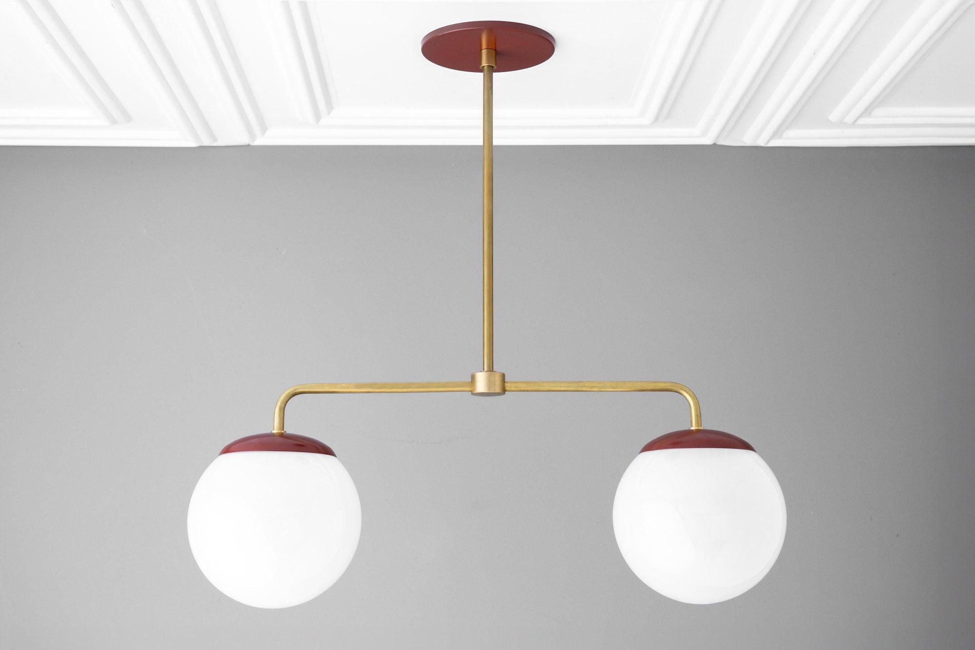 Mid-century modern chandelier with two large white glass globes and raw brass arms with red ceiling mount and globe caps. - CHANDELIER MODEL NO. 3883