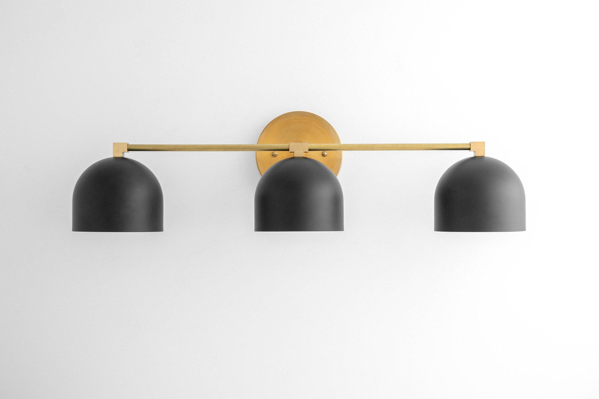 Mid-century modern vanity light with three black dome shades and a brass horizontal bar mount. - VANITY LIGHT MODEL NO. 7565