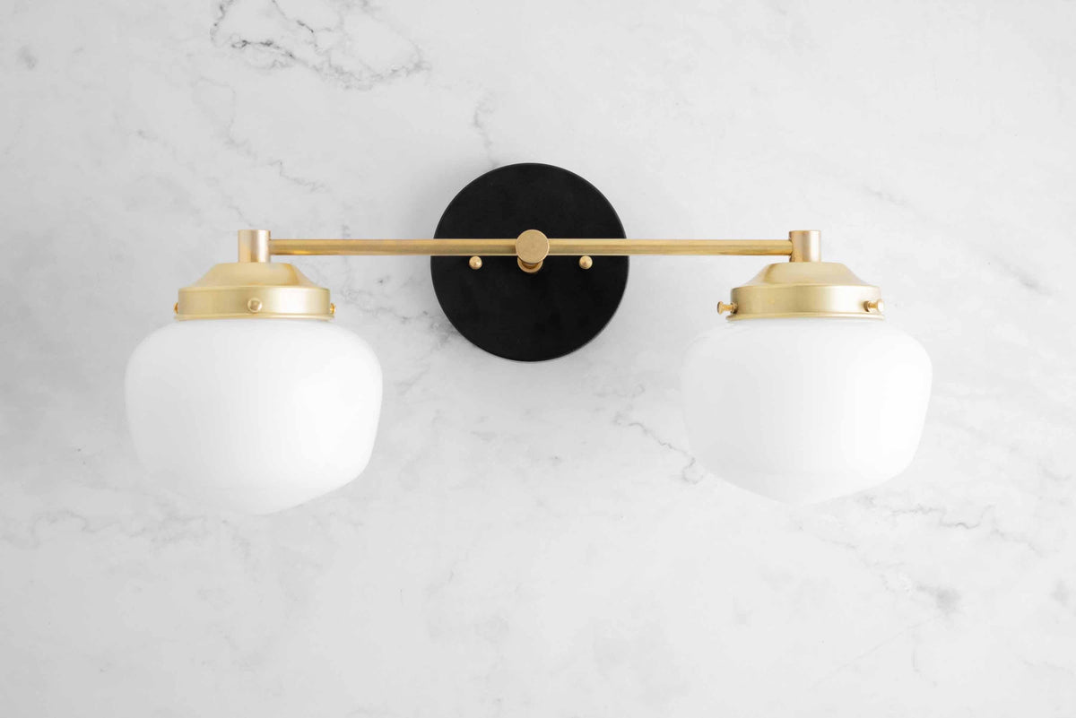 Mid-century modern vanity light with two white globe shades and brass finish on marble wall background. - VANITY LIGHT MODEL NO. 5799