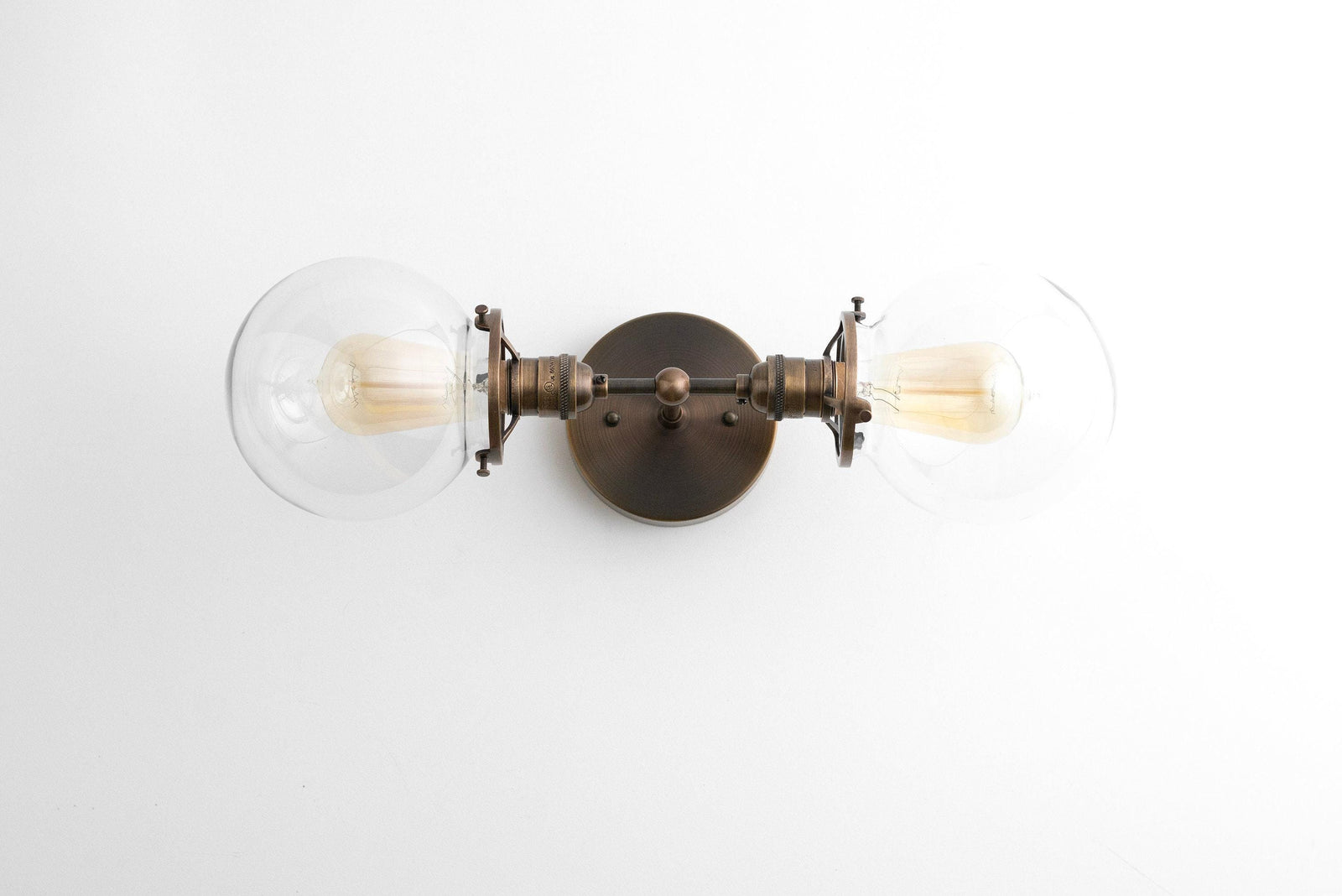Art Deco style black metal vanity light with two clear globe bulbs and a round wall mount. - VANITY LIGHT MODEL NO. 7350