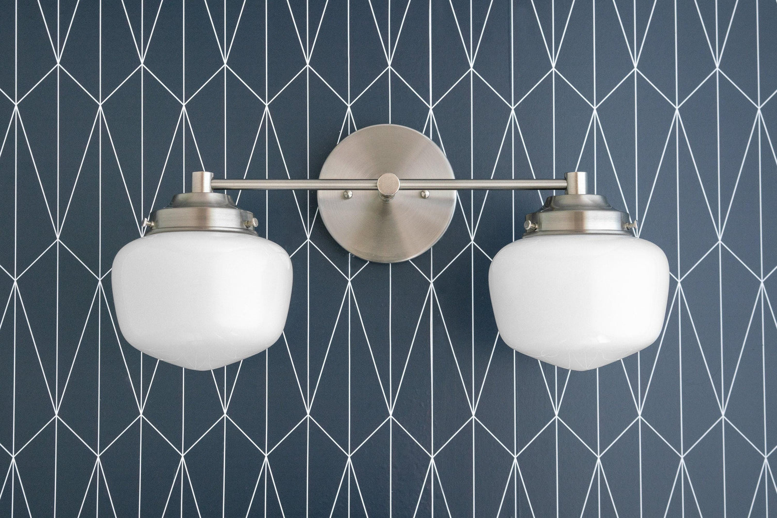 Mid-century modern 2-bulb vanity light in brushed nickel with white globe shades on geometric blue wall. - VANITY LIGHT MODEL NO. 5799