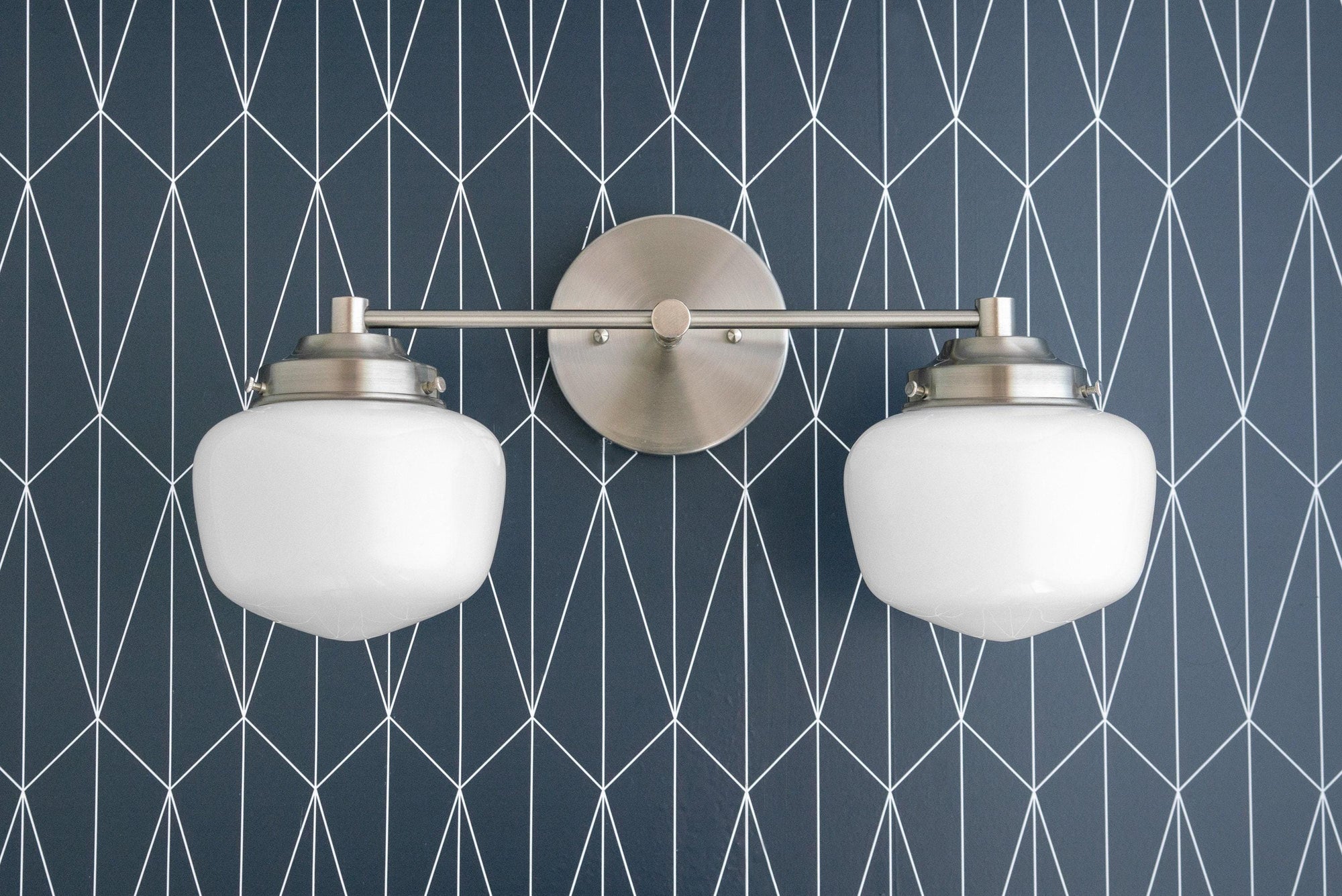 Mid-century modern 2-bulb vanity light in brushed nickel with white globe shades on geometric blue wall. - VANITY LIGHT MODEL NO. 5799