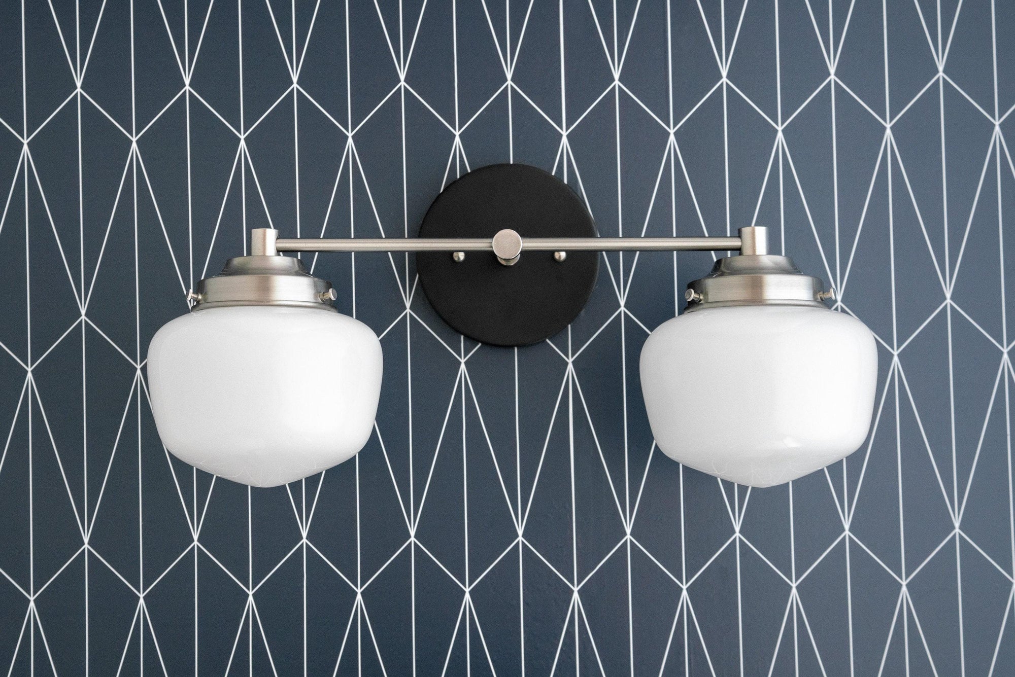Mid-century modern 2-bulb vanity light with polished nickel arms and white globe shades on black round backplate. - VANITY LIGHT MODEL NO. 5799